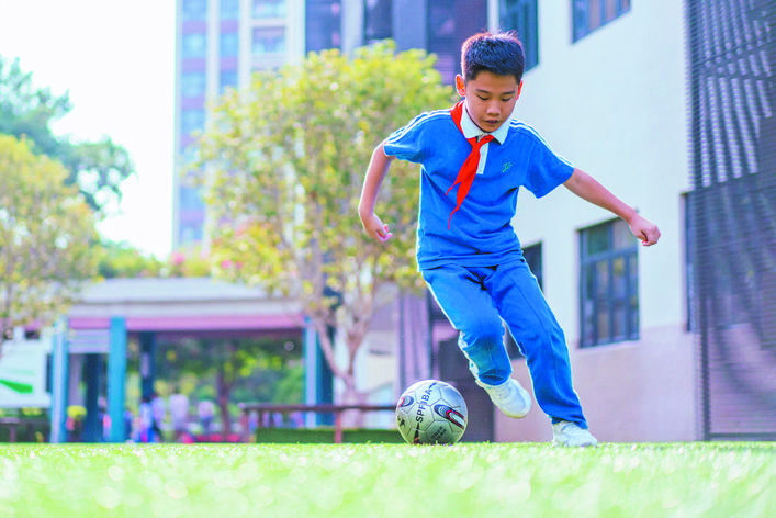     南山学校，小学生利用课余时间练习足球技巧。