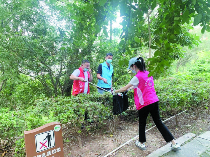     志愿者在飞鹅岭公园捡垃圾。