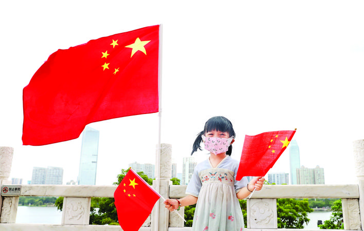 　　一名小朋友手拿国旗在市区合江楼留影。惠州日报记者钟畅新 摄