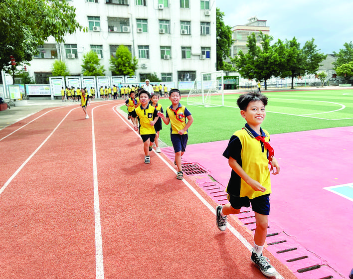     学生们在新修的跑道上跑步。