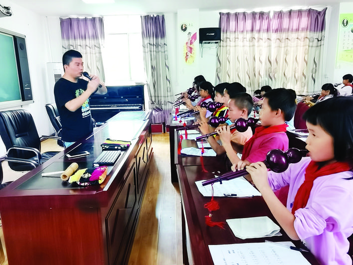     惠城区音乐教师为册亨山区学校的学生上葫芦丝课。