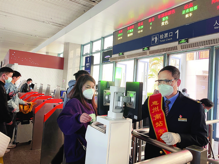     春运期间，惠州南站工作人员引导旅客通过自助检票闸机。    惠州日报记者许文昌 通讯员刘绿平 摄