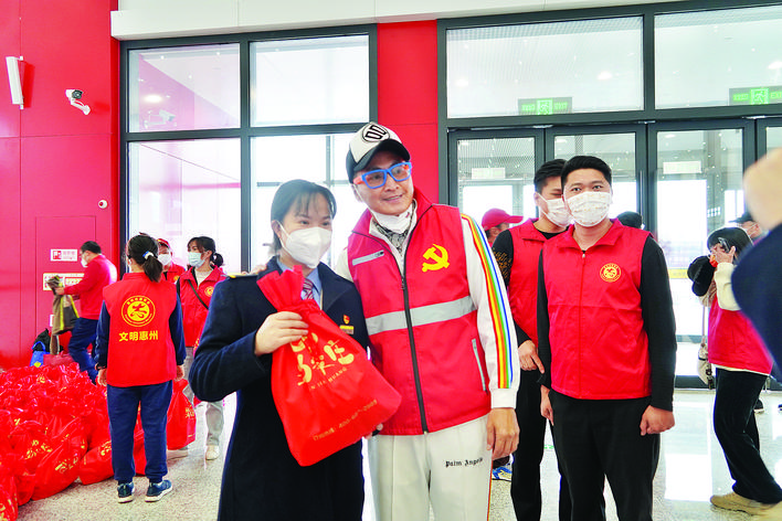     何家劲等网络名人来到现场，与志愿者一起服务旅客。