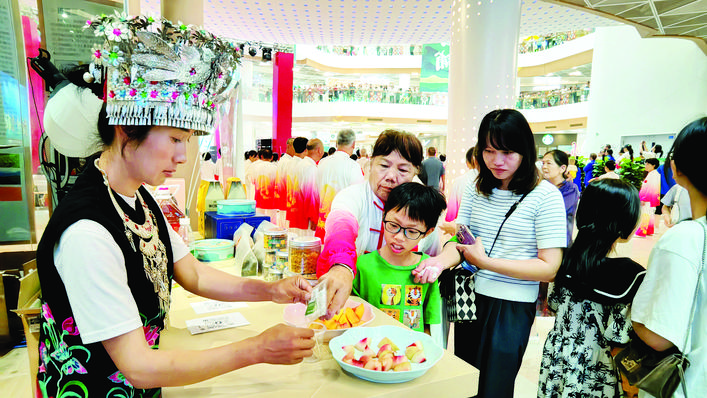     市民在党群“山海同心”工程展示馆品尝晴隆水果。    惠州日报记者匡湘鄂 通讯员范巧萍 摄