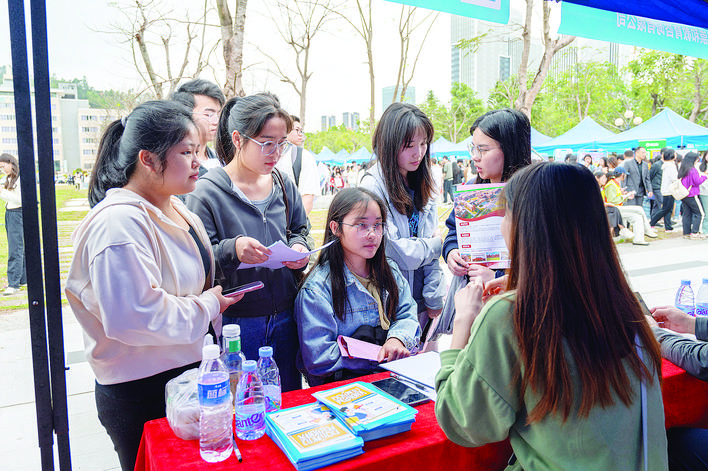     学生在春季招聘会摊位了解校招信息。    惠州日报记者洪鹊儿 摄