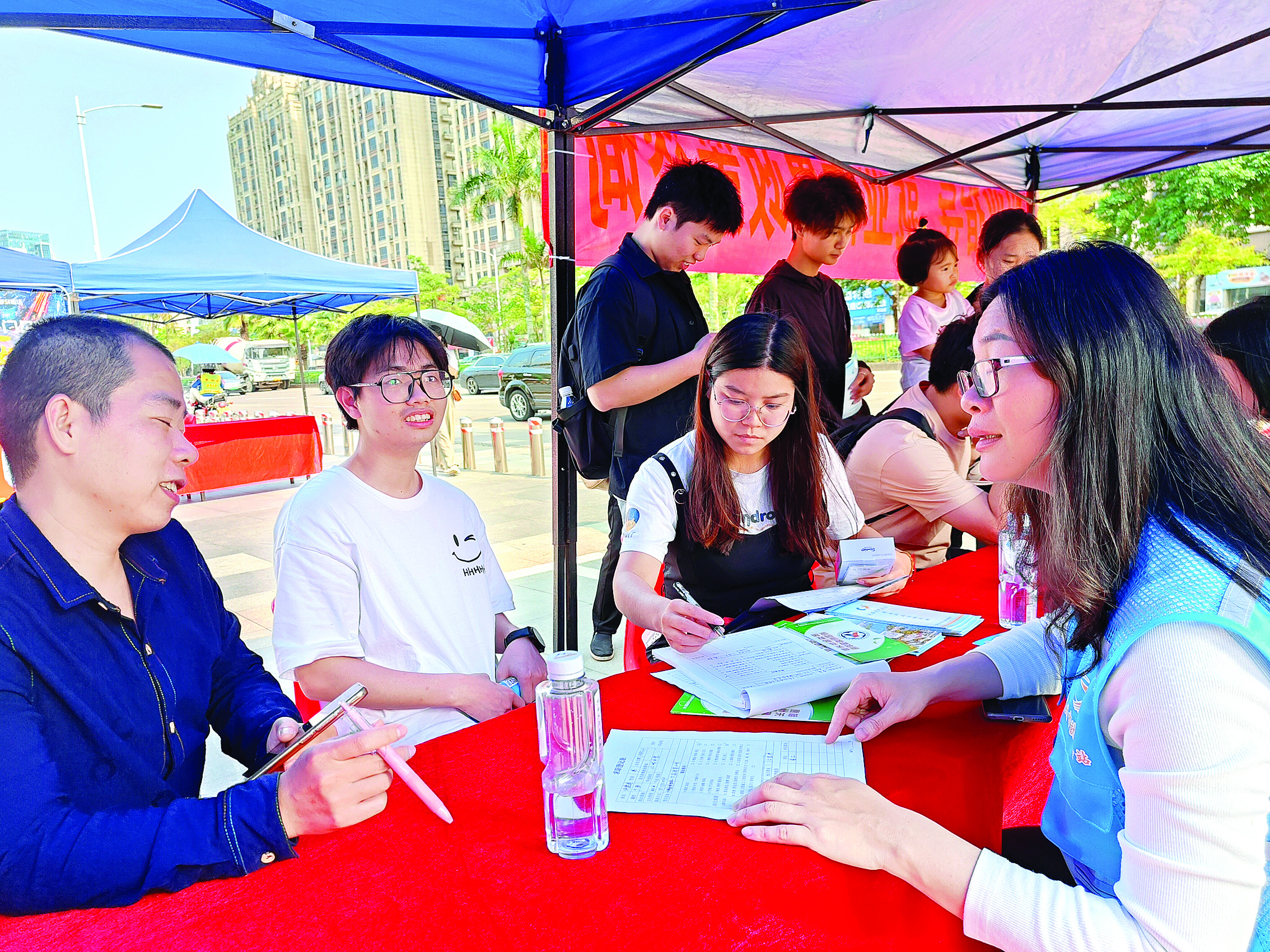     就业驿站工作人员为求职者提供就业登记和信息服务。