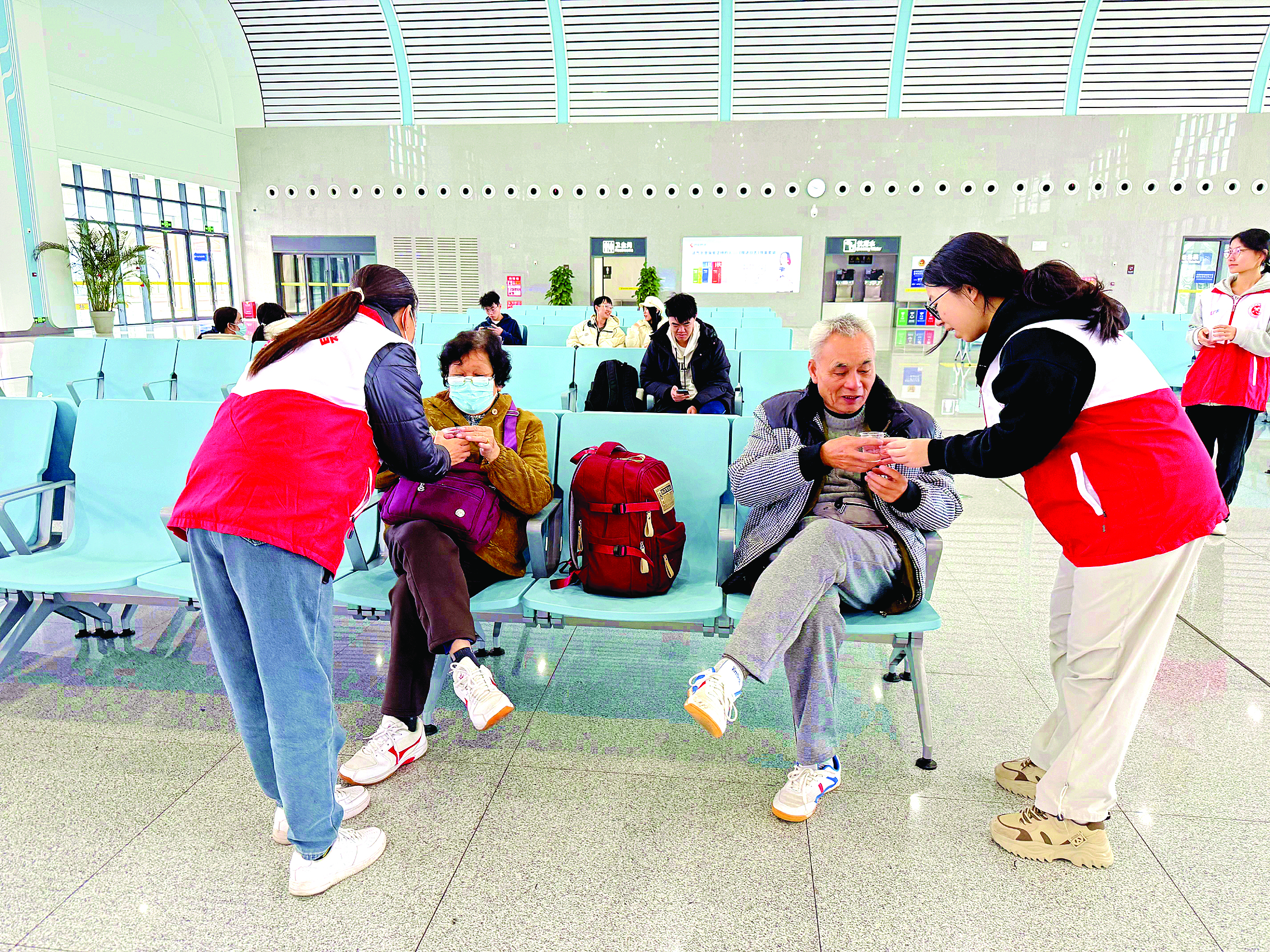     志愿者递上热茶为旅客暖身子。