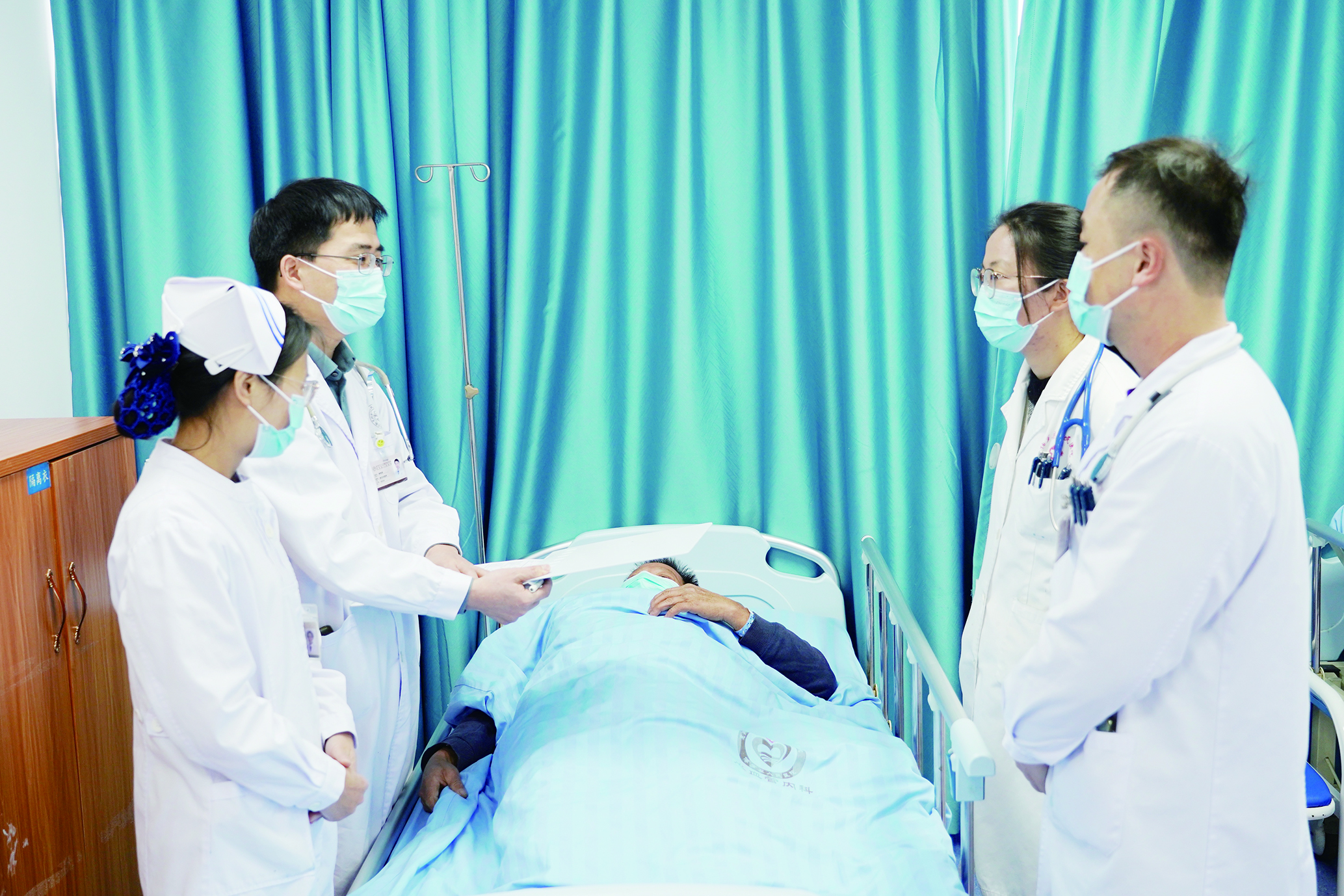     谢桂庭（左二）带领医护团队查房。
