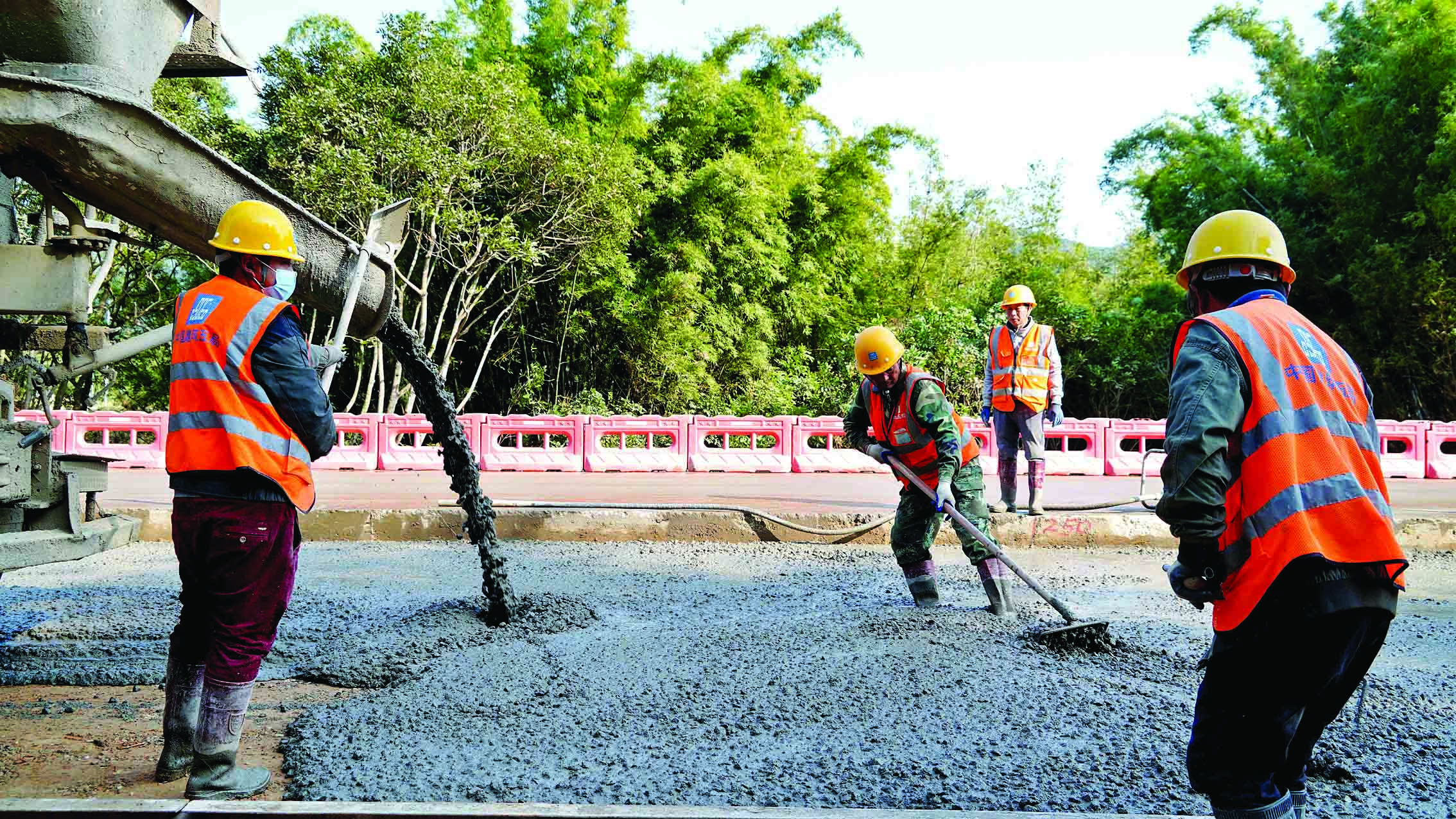     省道254线龙门路段，工人在扩建道路上浇筑混凝土。