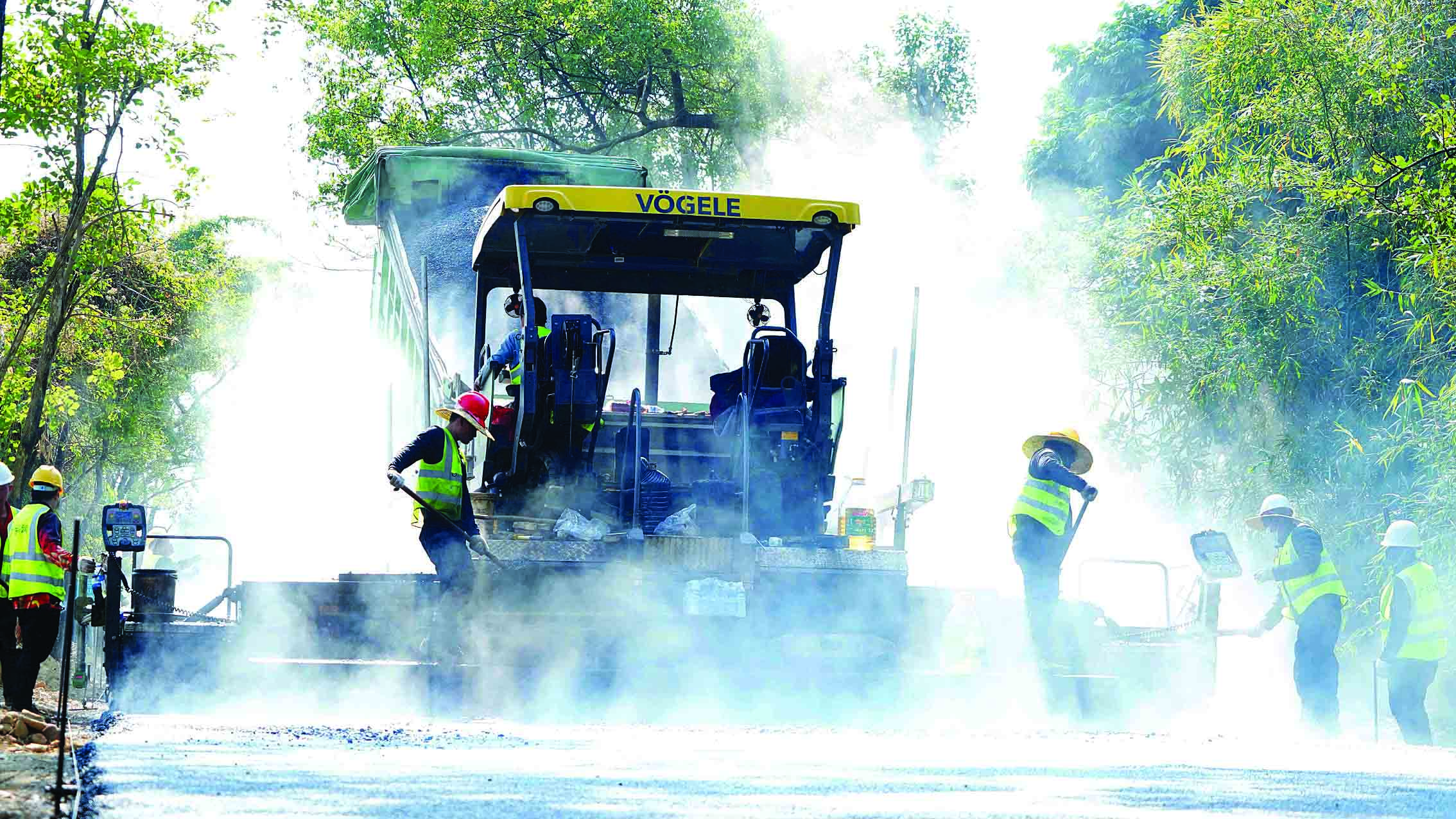     省道254线博罗路段，工人正在铺设沥青，如火如荼的施工场面宛若水墨画。