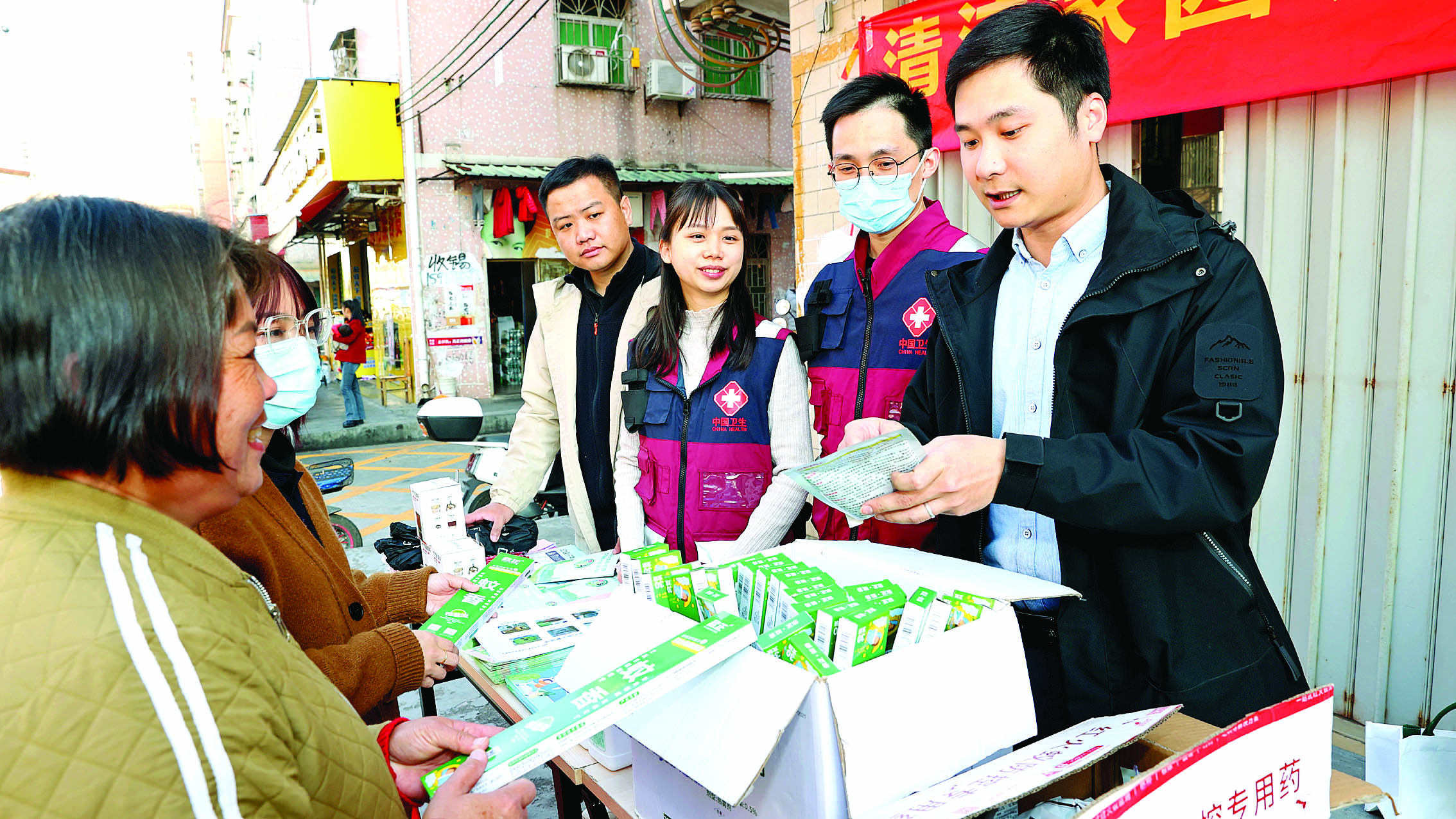     工作人员向居民派发灭蚊虫药品。    惠州日报记者钟玮 通讯员钟家俊 黄希婕 刘铭 摄