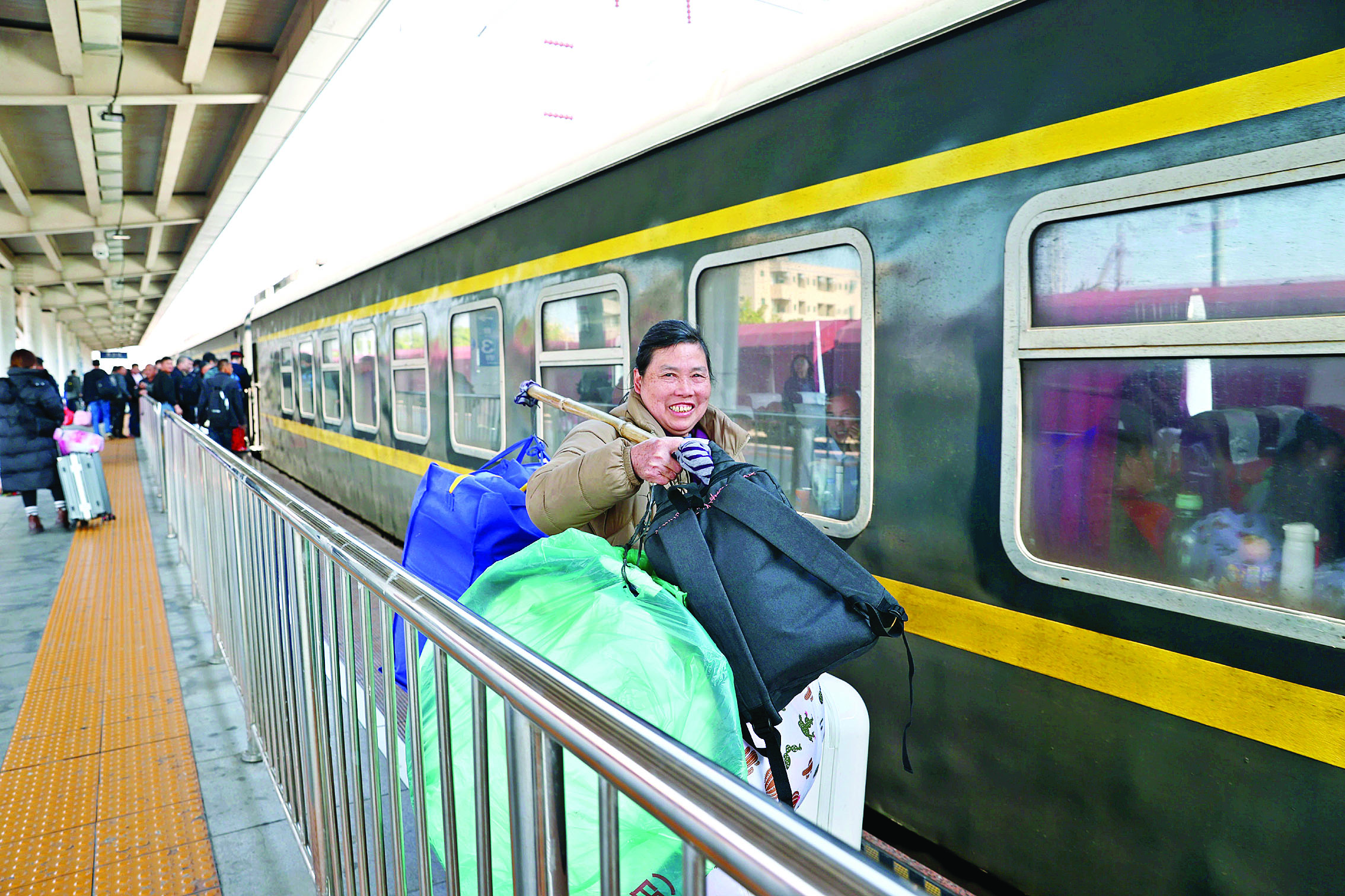     旅客挑着大包小包赶火车。惠州日报记者杨建业 摄