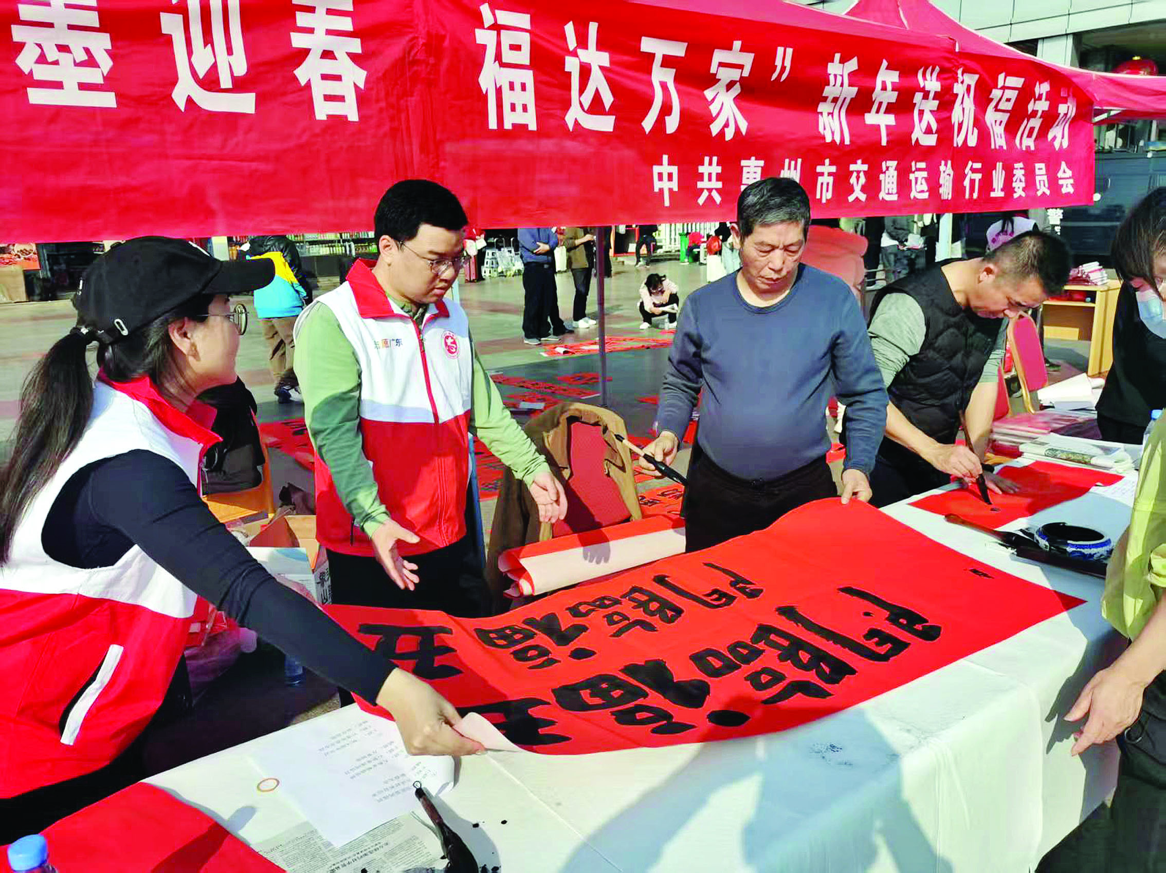     书法家在惠州火车站为旅客写春联。惠州日报记者戴建 通讯员戴晓岚 摄
