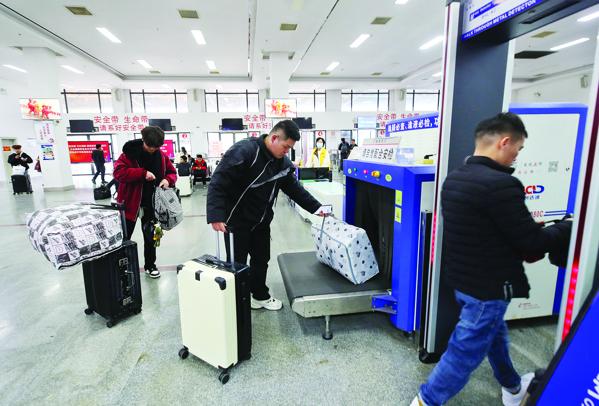     1月26日上午，惠州南线汽车客运站，乘客有序通过安检。惠州日报记者钟畅新 摄