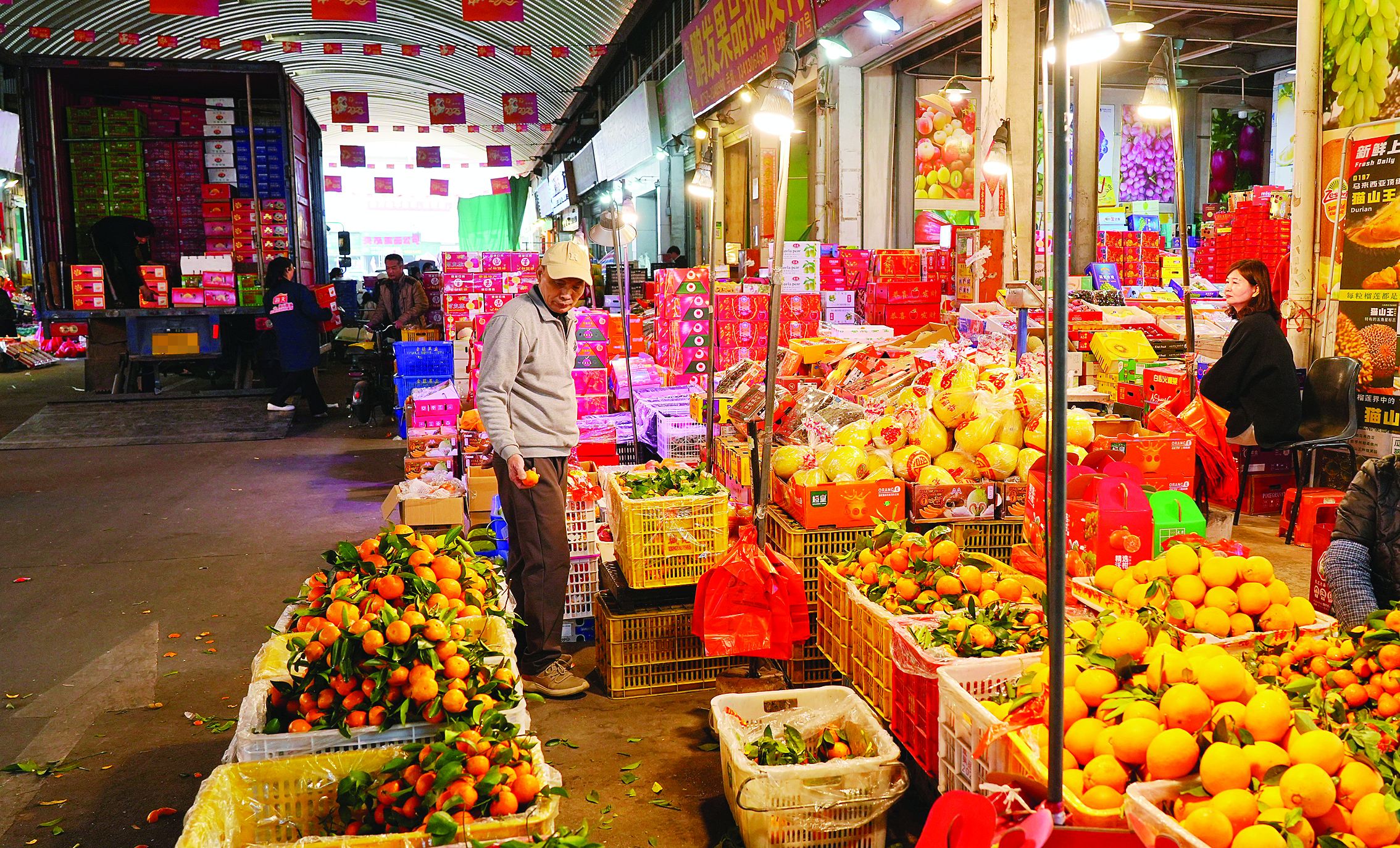     水果批发商行门前堆满了热销水果。惠州日报记者朱金赞 摄