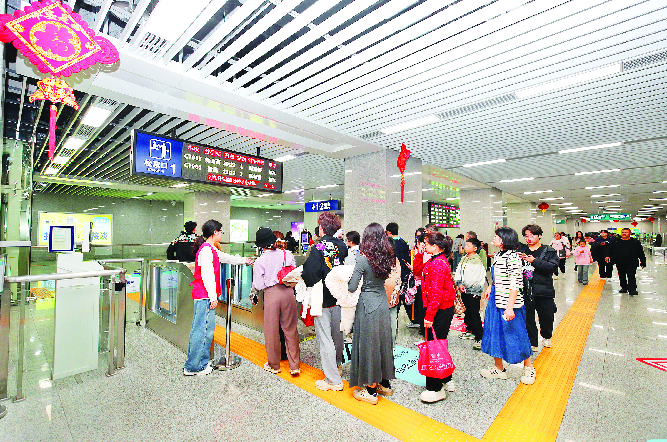     广惠城际西湖东站乘客排队过闸。