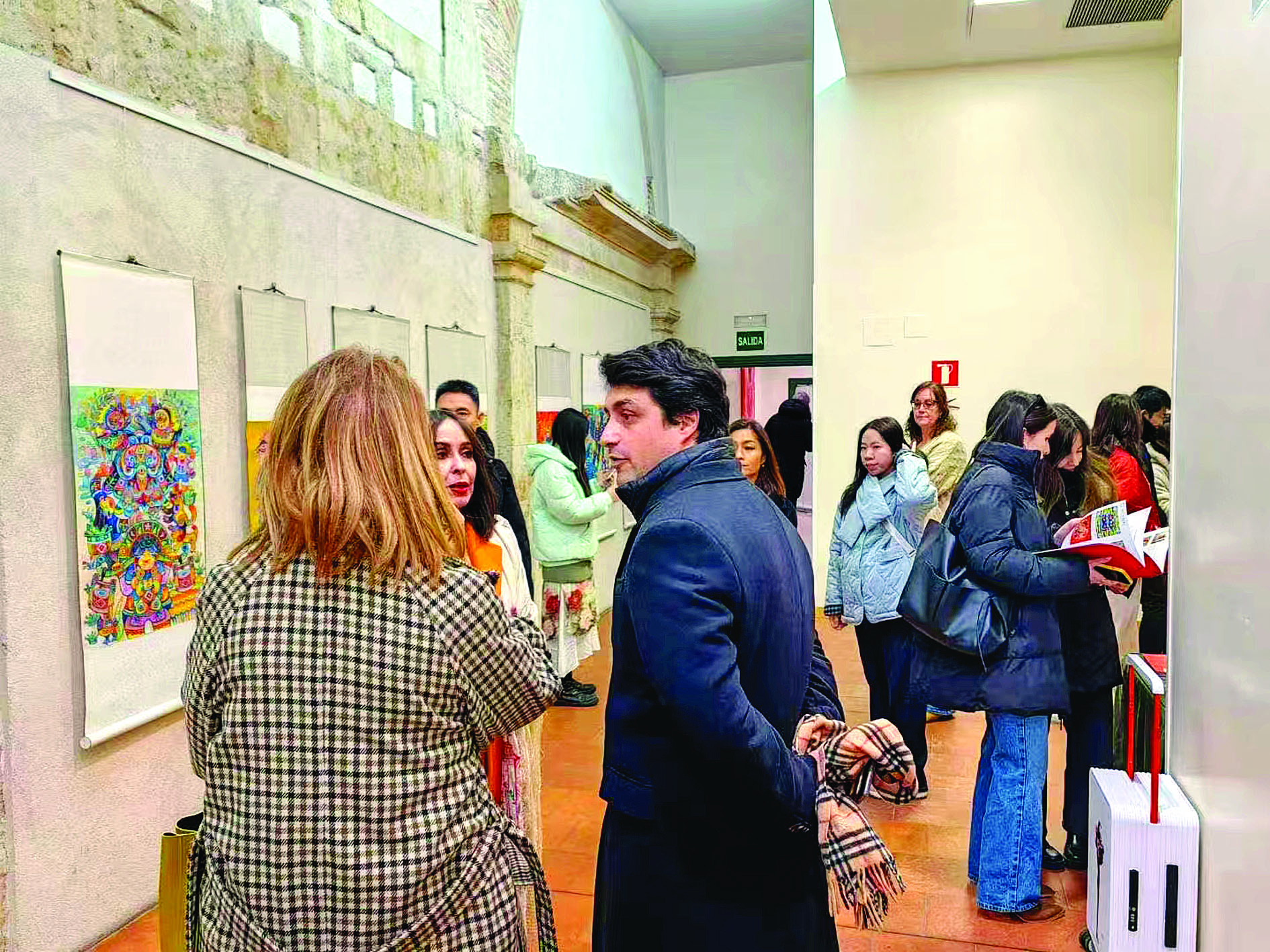     西班牙市民在欣赏龙门农民画。图片由龙门县文化馆提供