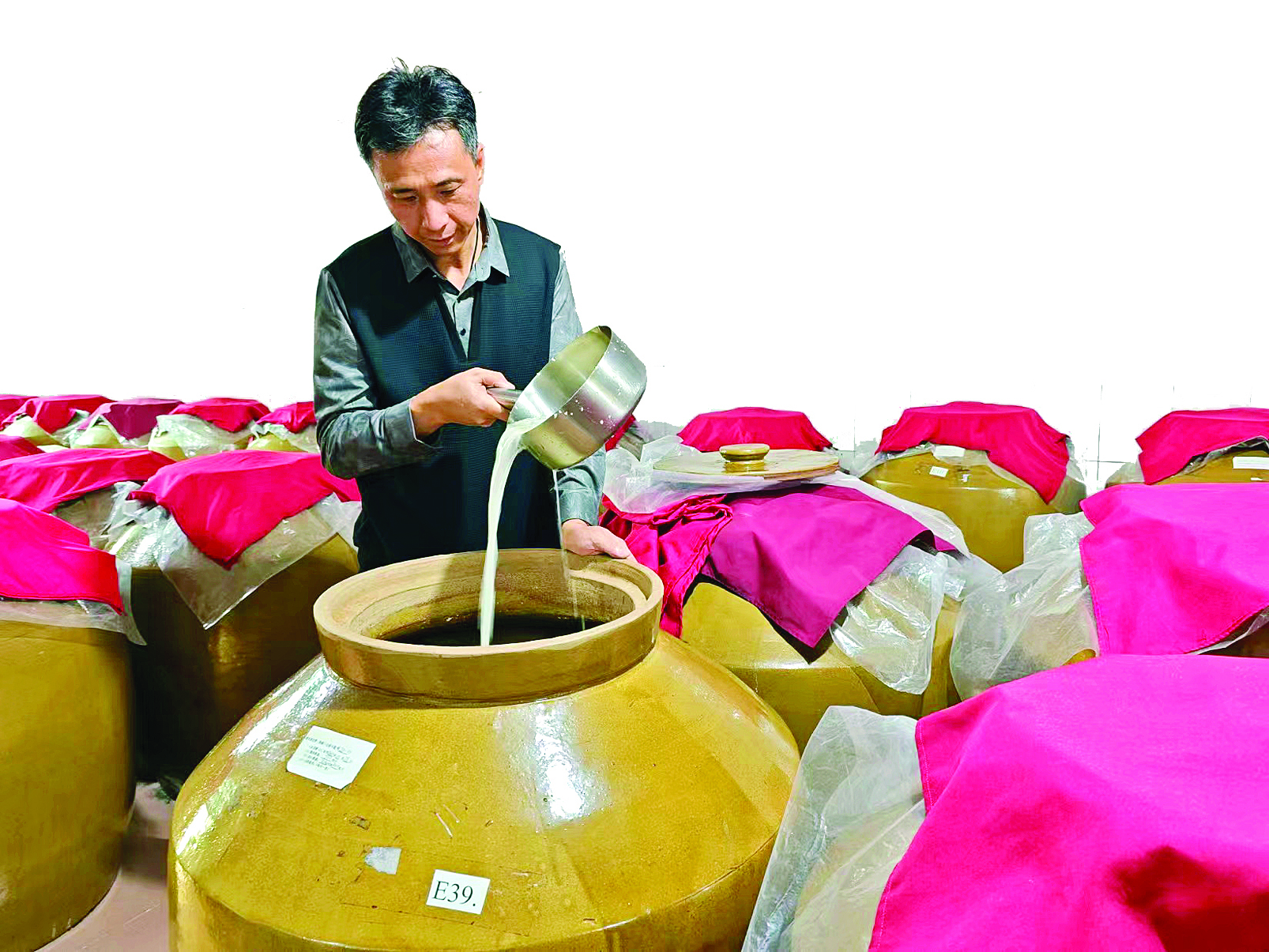     周毅检查糯米酒酿造情况。