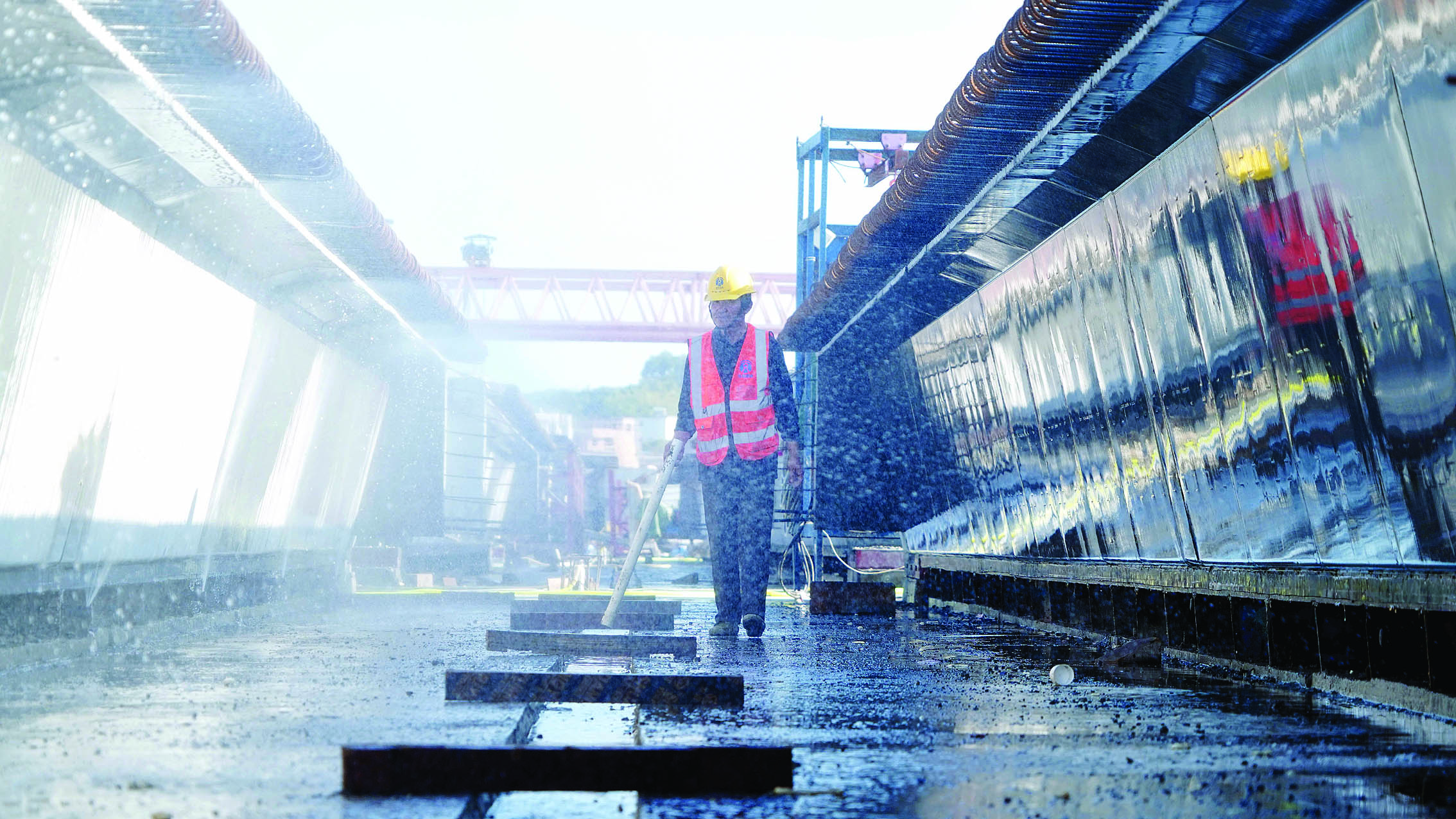     在7号制梁场，一片片预制梁整齐地摆放在场内，工人正在进行预制梁养护。惠州日报记者李松权 摄