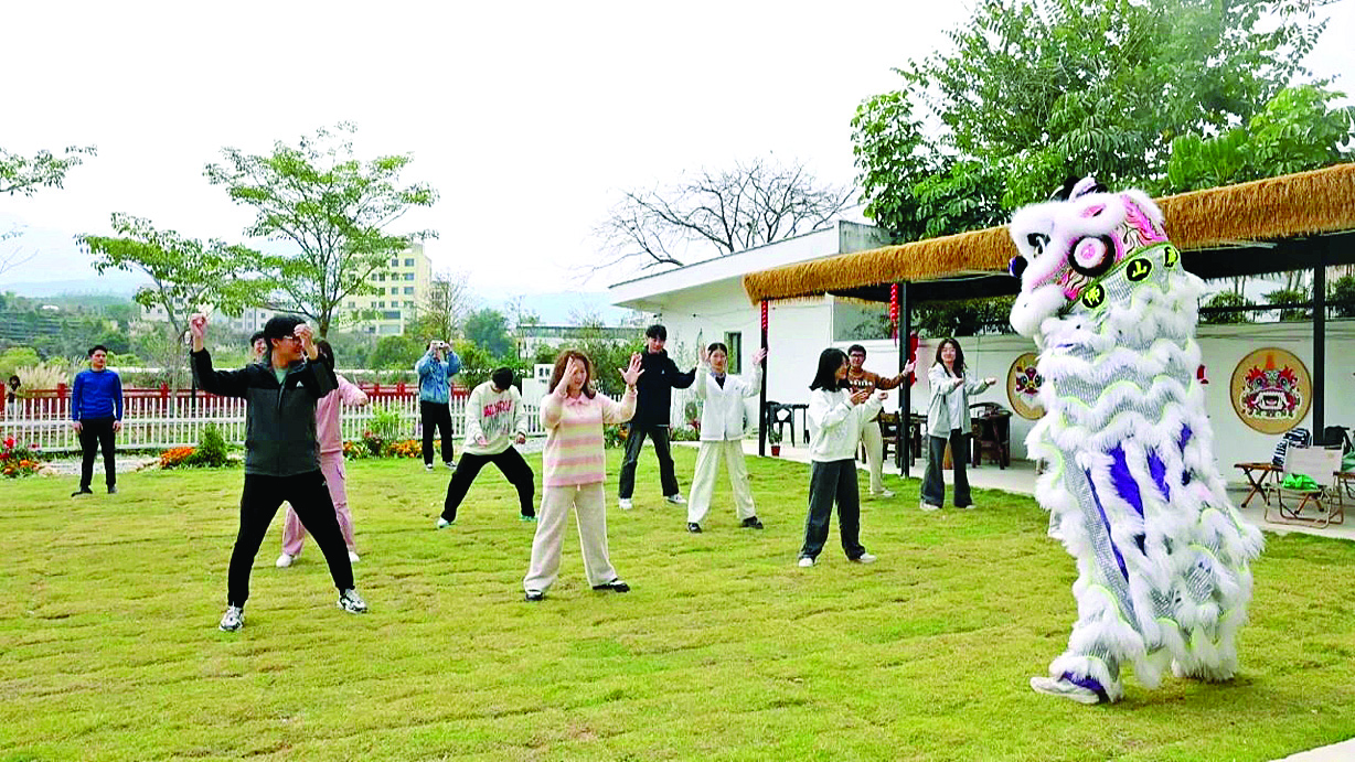     游客在白盆珠镇民宿体验舞狮非遗文化。