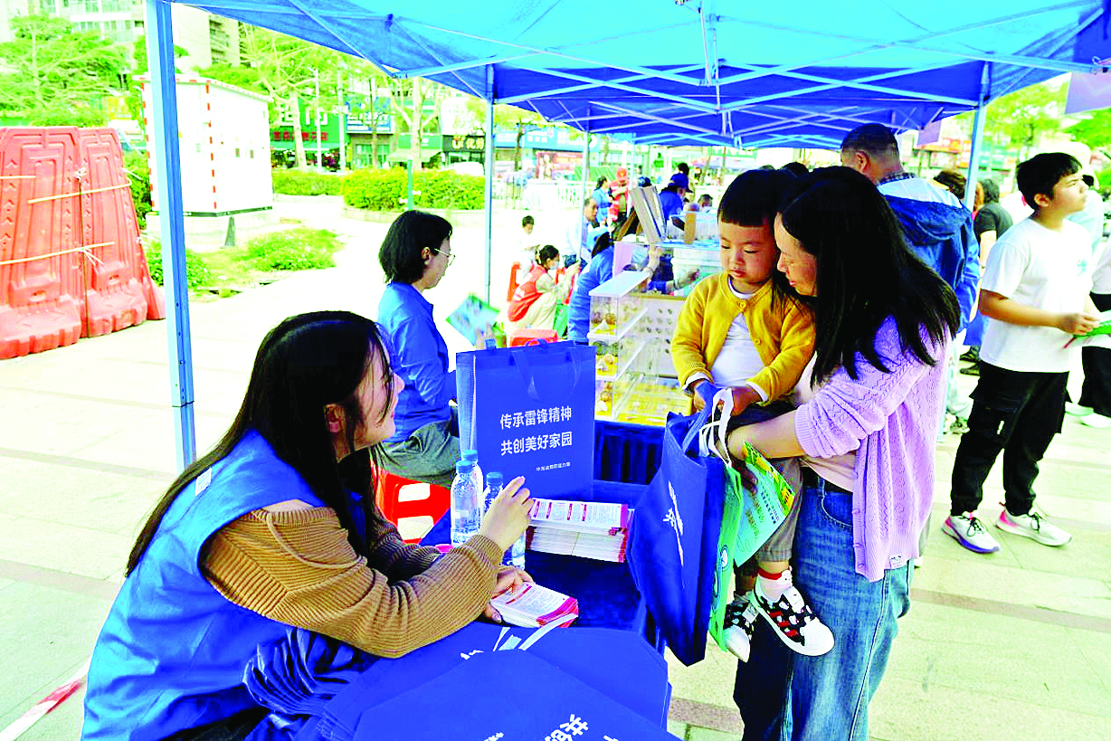     志愿者们向居民宣传环保知识。    惠州日报记者张宇琪 通讯员陈芳 摄