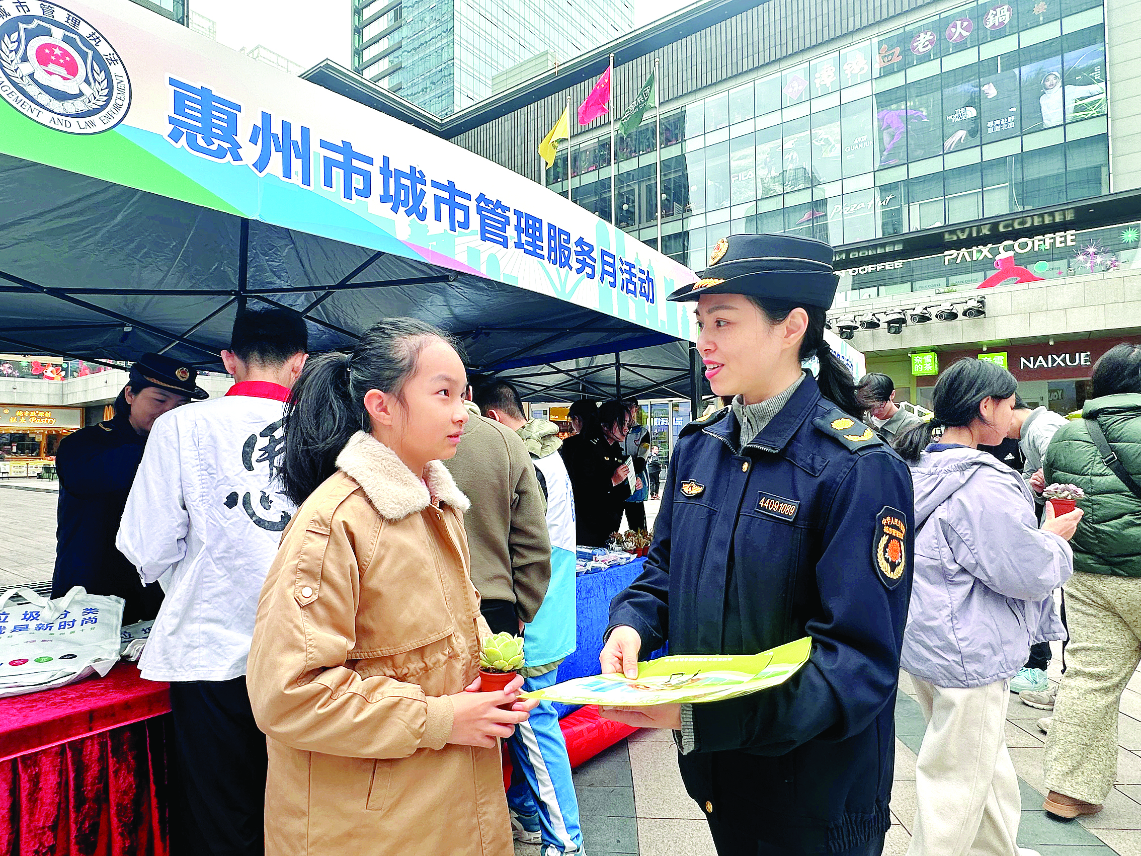     城管执法人员向市民科普垃圾分类知识。 惠州日报记者谭琳 摄