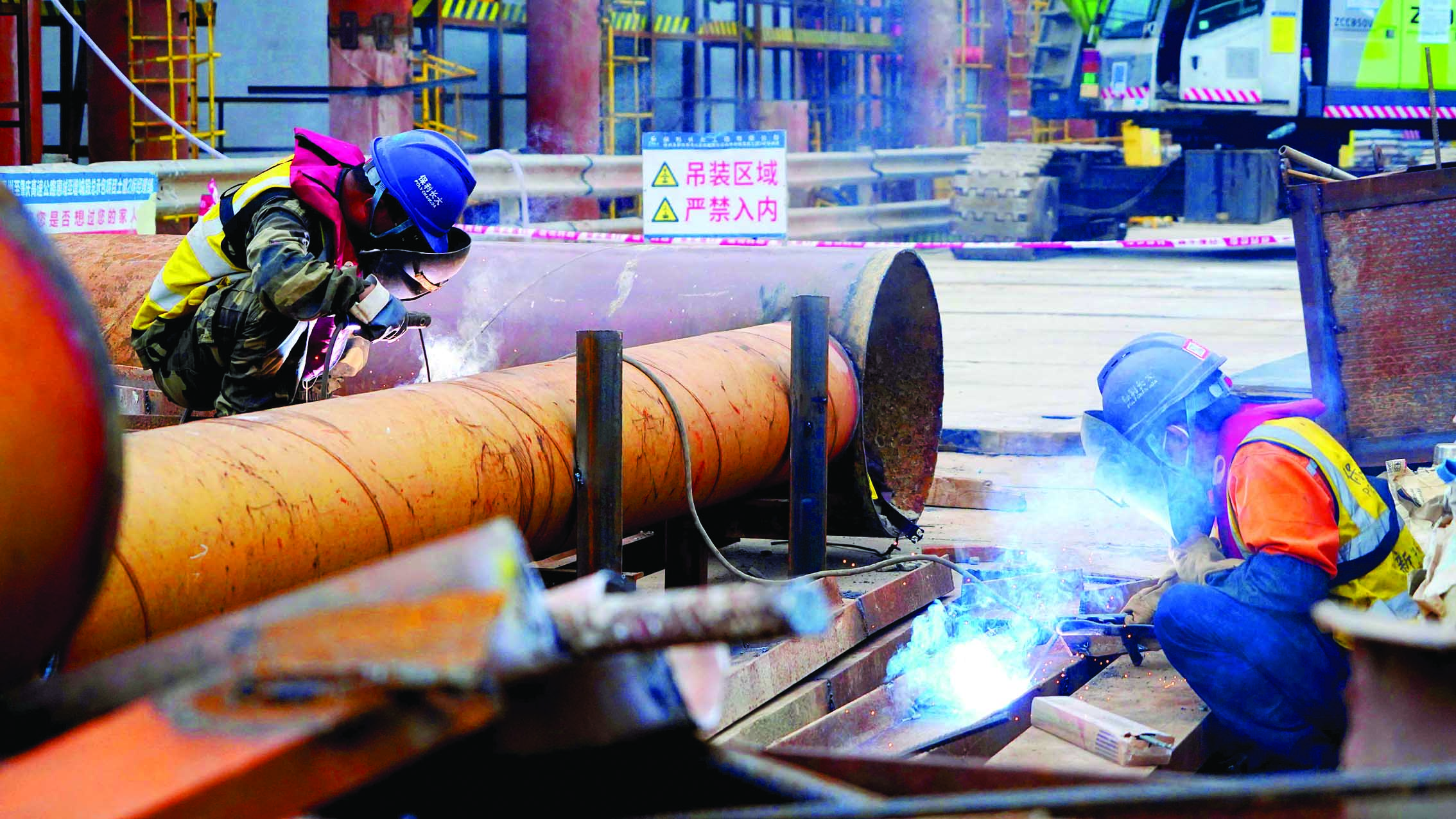     惠肇高速博罗罗阳段东江特大桥施工现场，工人正在进行钢管转运和切割。