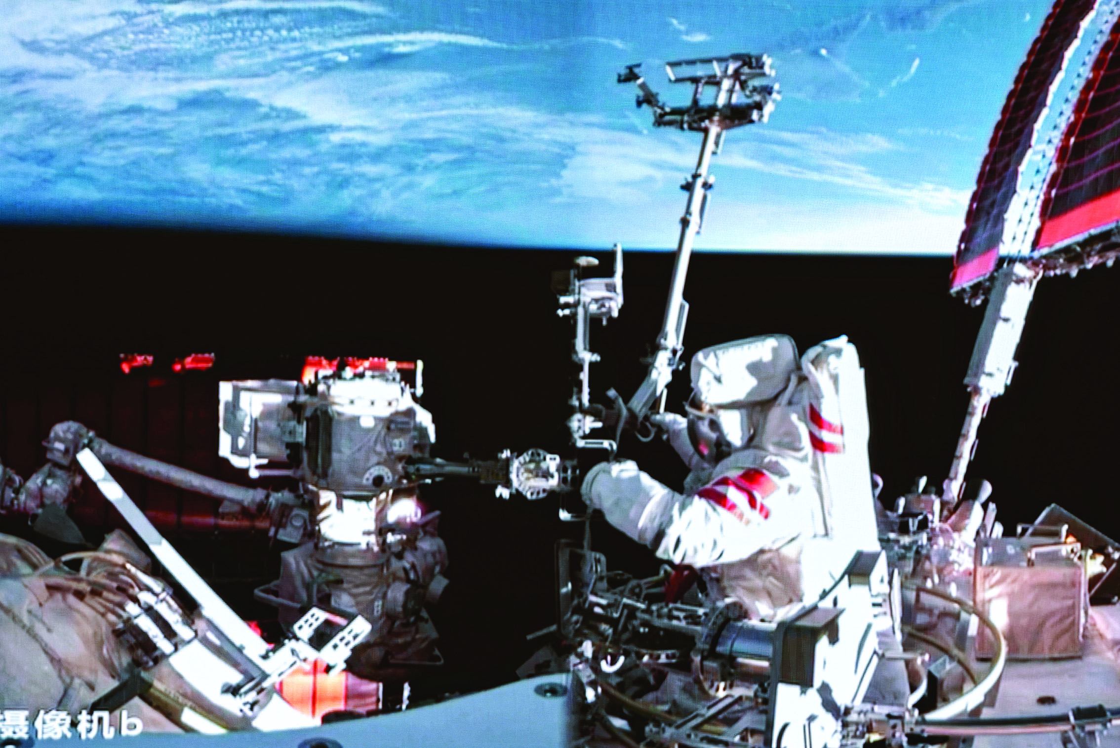     3月21日在北京航天飞行控制中心拍摄的神舟十九号航天员蔡旭哲在空间站组合体舱外工作的画面。新华社发