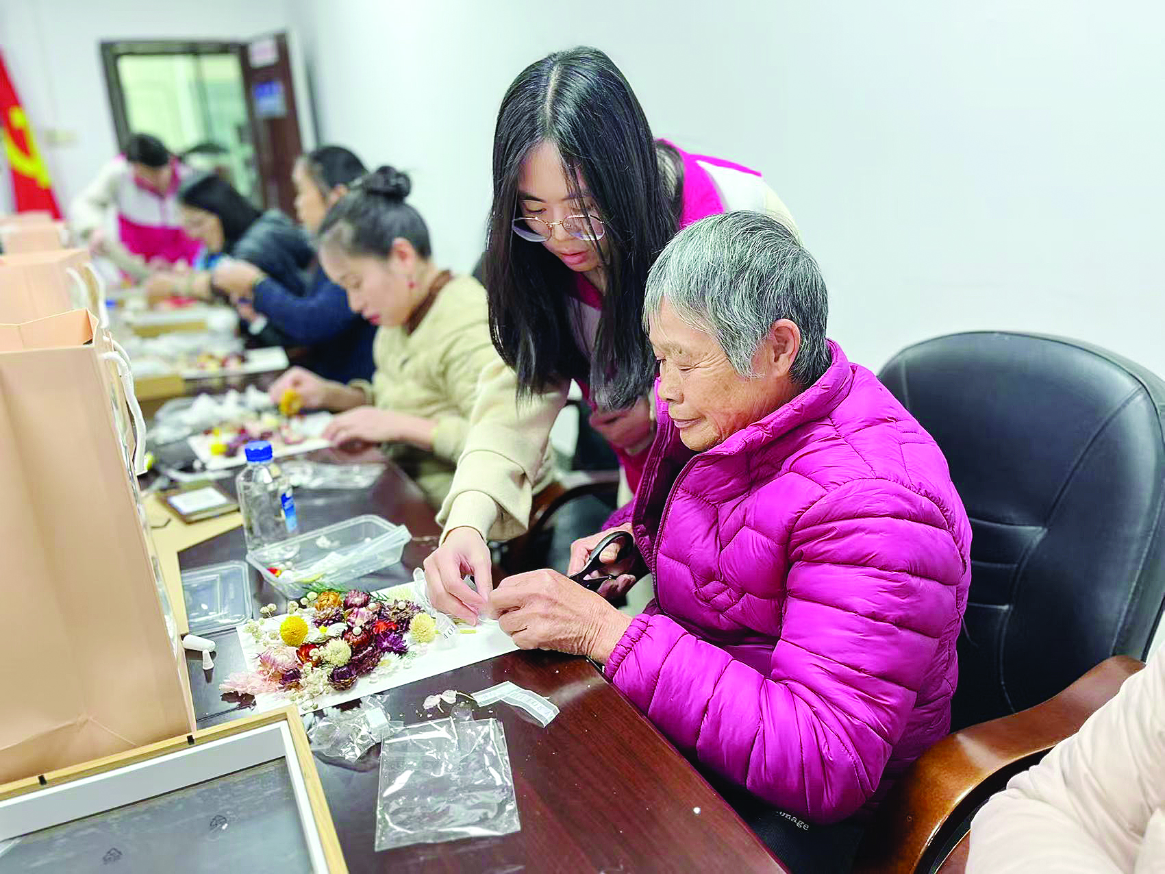     吕诗旖（右二）帮助村里老人做手工。图片由驻村干部提供