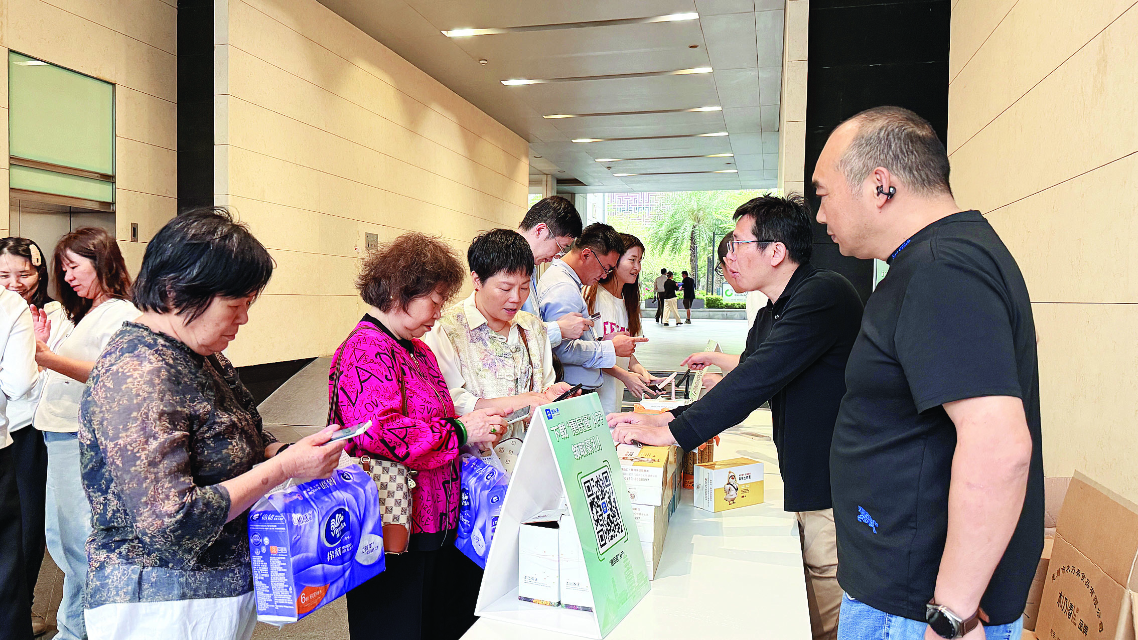     活动现场，市民积极“尝鲜”体验惠民通APP。惠州日报记者谢宝树 摄