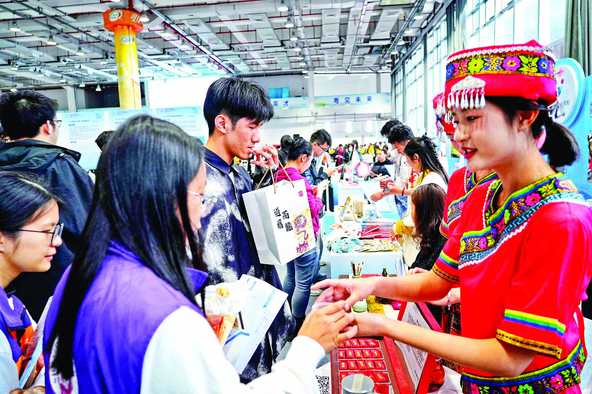     工作人员身着少数民族服饰助力招聘会引才。