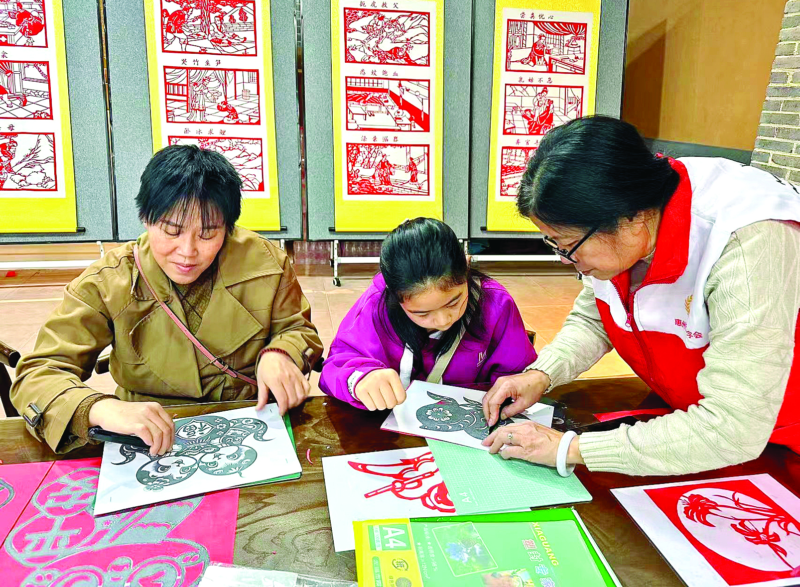     志愿者在教亲子家庭学习剪纸。通讯员郭丽媚供图