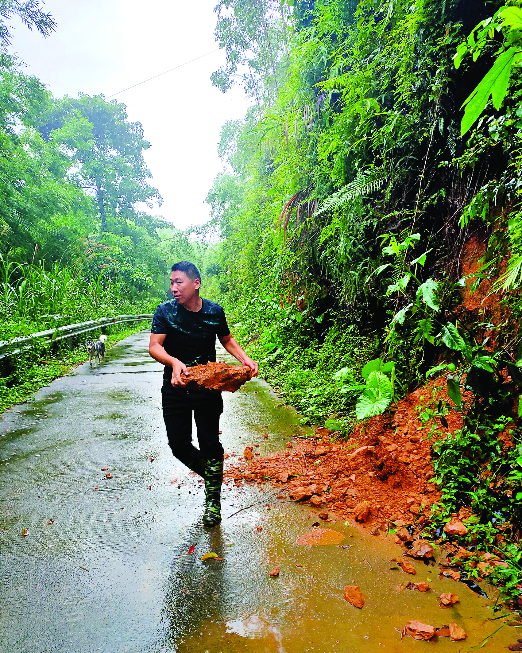     杨朝儒正在清理山体滑坡后道路上的土石。图片由驻村干部提供