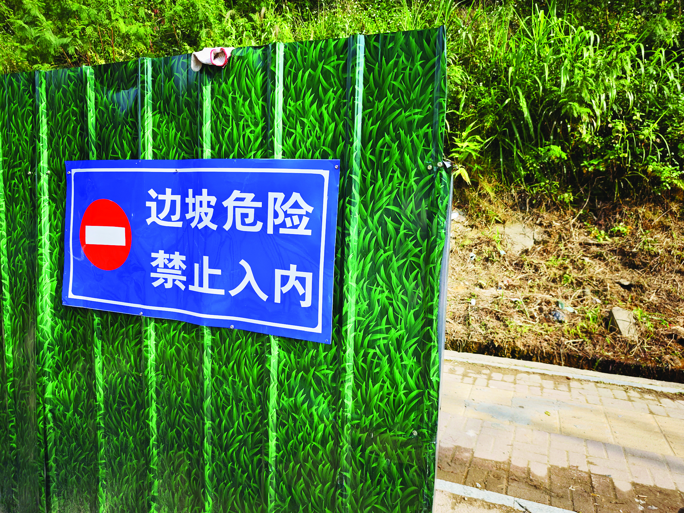     围挡外侧有“边坡危险 禁止入内”警示牌。    惠州日报记者香金群 摄