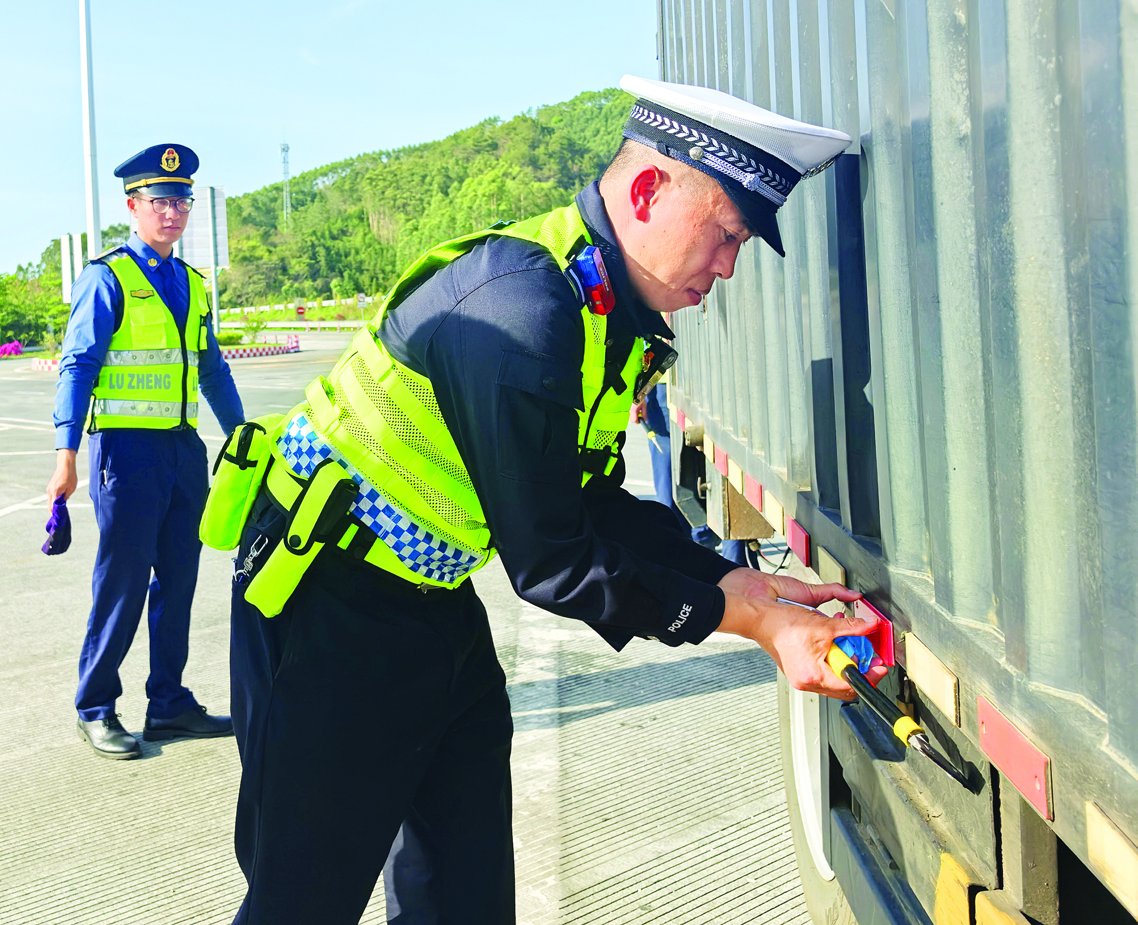     交警在粘贴反光标识。惠州日报记者刘建威 摄
