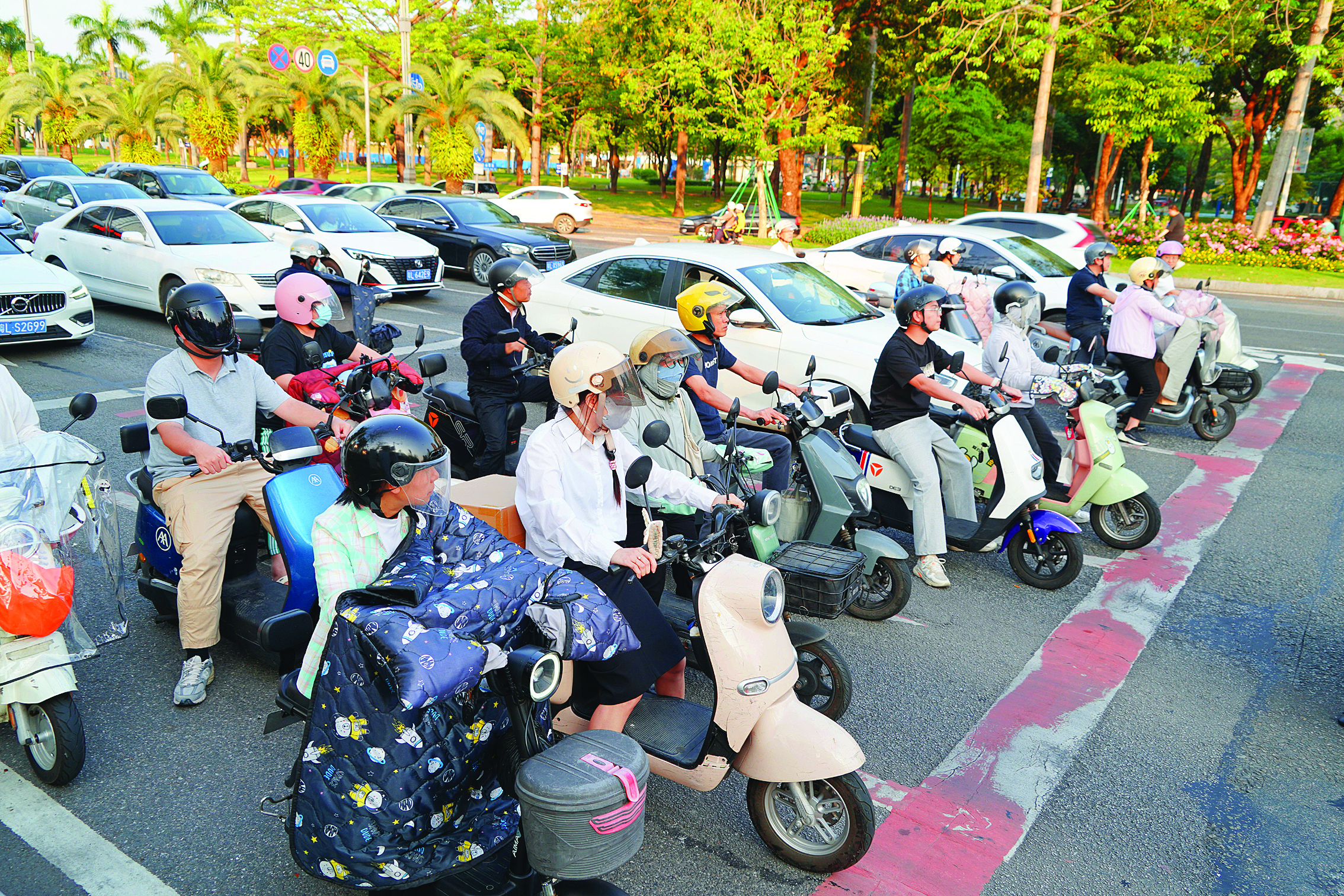     驾驶电动自行车的市民在红灯前有序等待。惠州日报记者李松权 摄