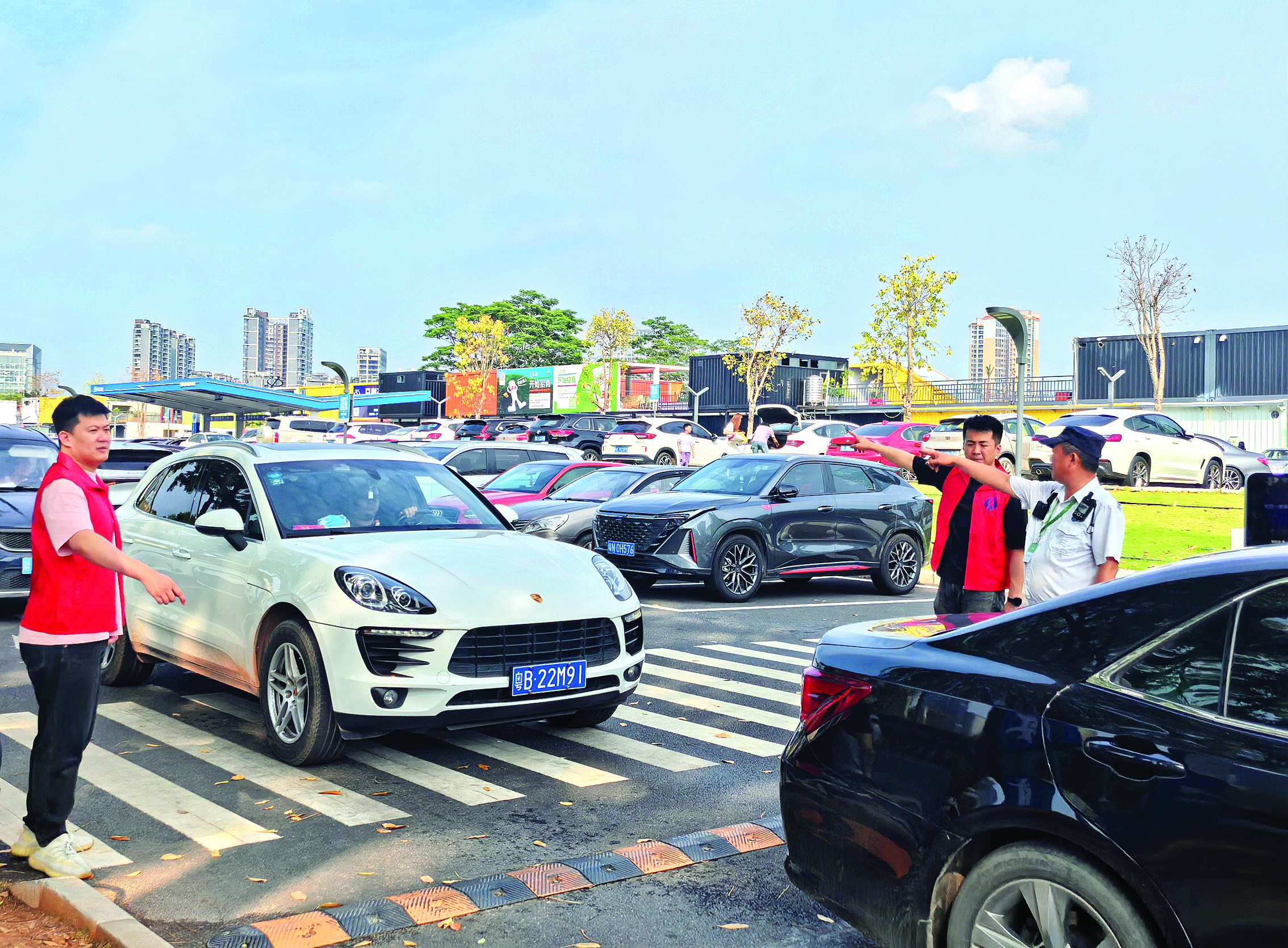     志愿者引导车辆有序进入停车场。