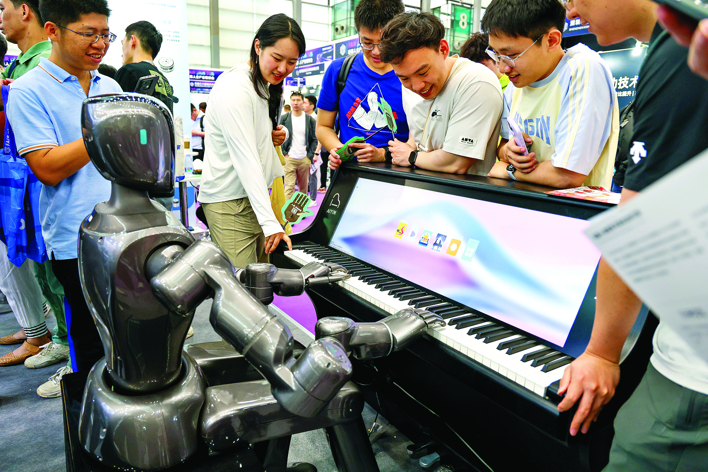     4月24日，参观者观看人形机器人弹钢琴。