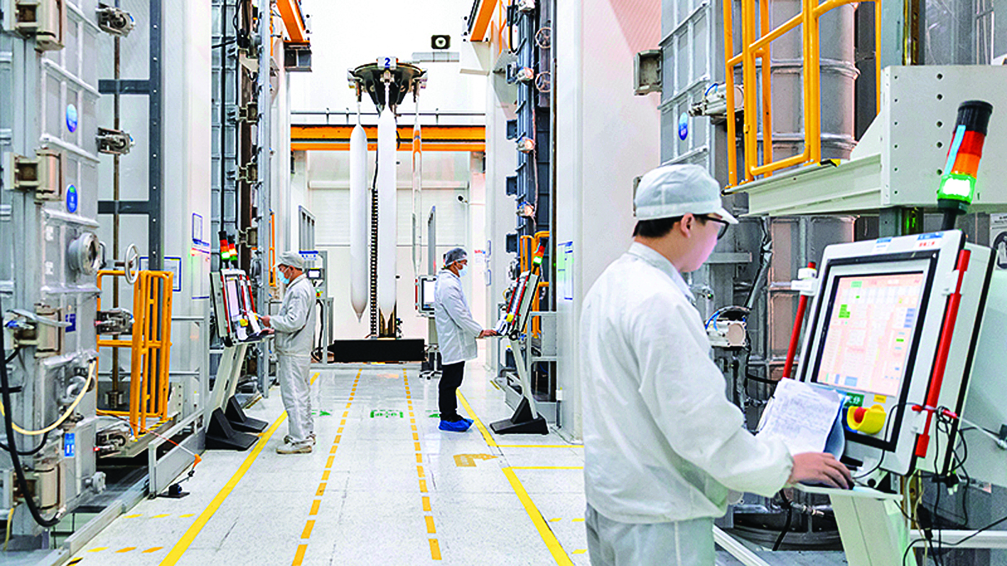     在位于苏州吴江区的亨通光纤光棒智能制造车间内，操作人员正在检查机器参数。本版图片 新华社发