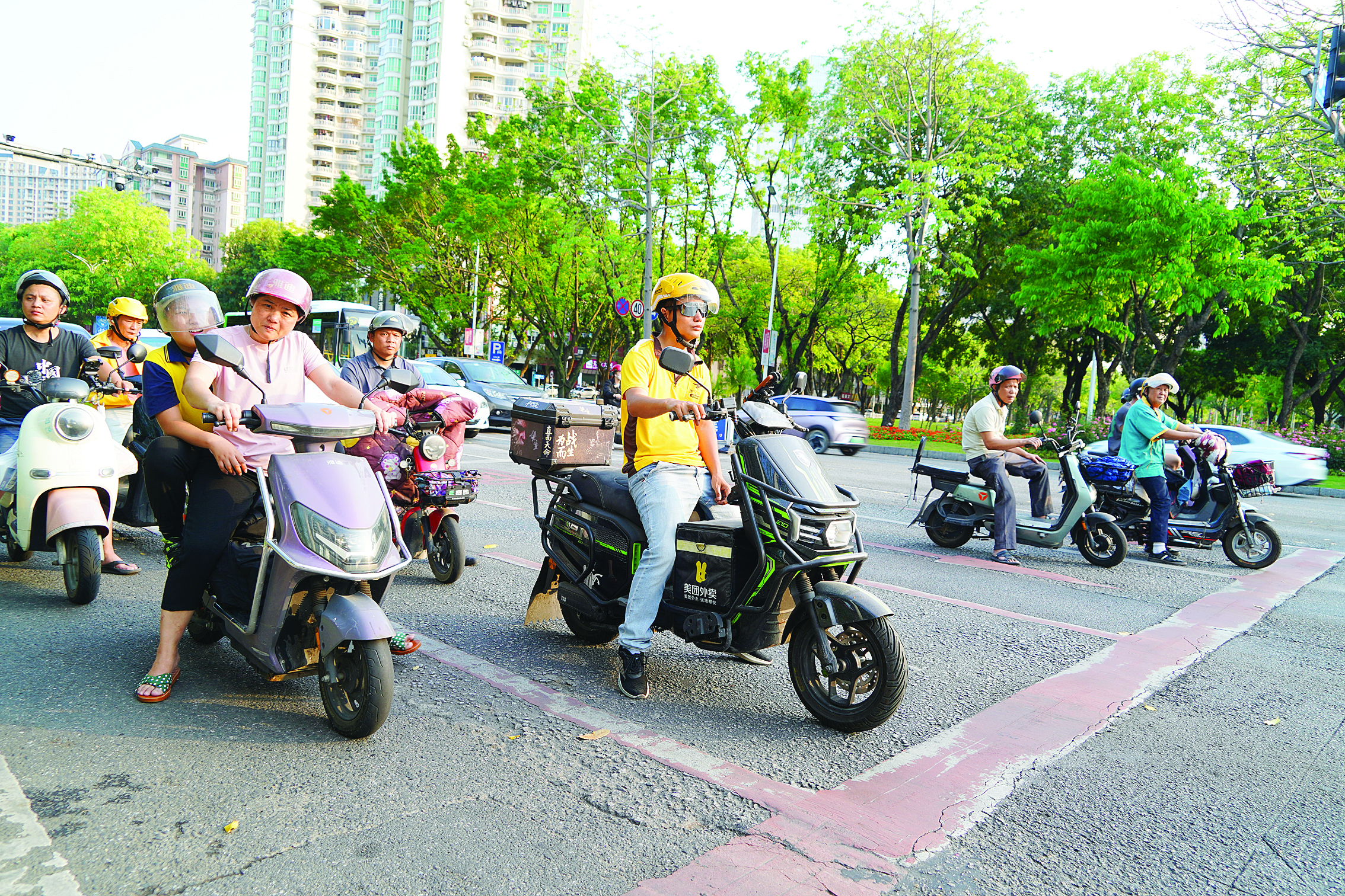    市民规范佩戴安全头盔驾乘电动自行车。惠州日报记者李松权 摄
