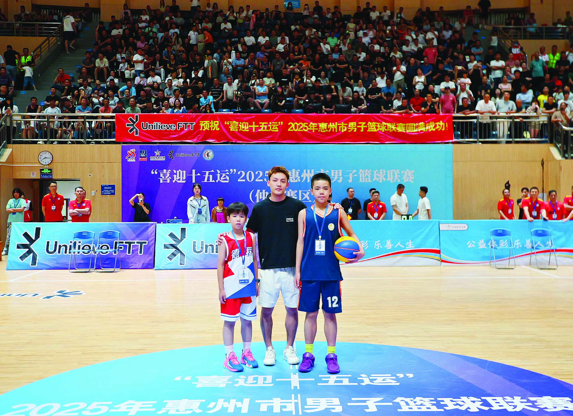     比赛现场，徐杰和两位篮球爱好者小朋友合照。惠州日报记者黄鑫威 摄