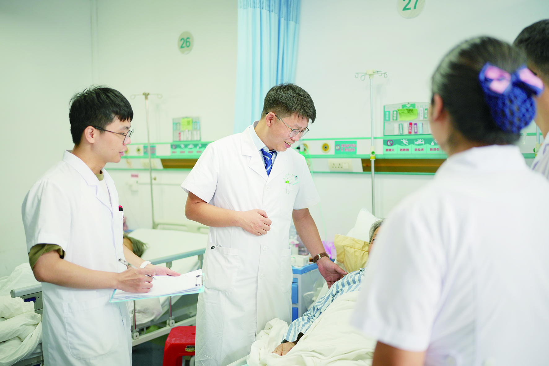     夏喜刚（中）带领医护团队查房。   本版图片惠州日报记者周楠 摄