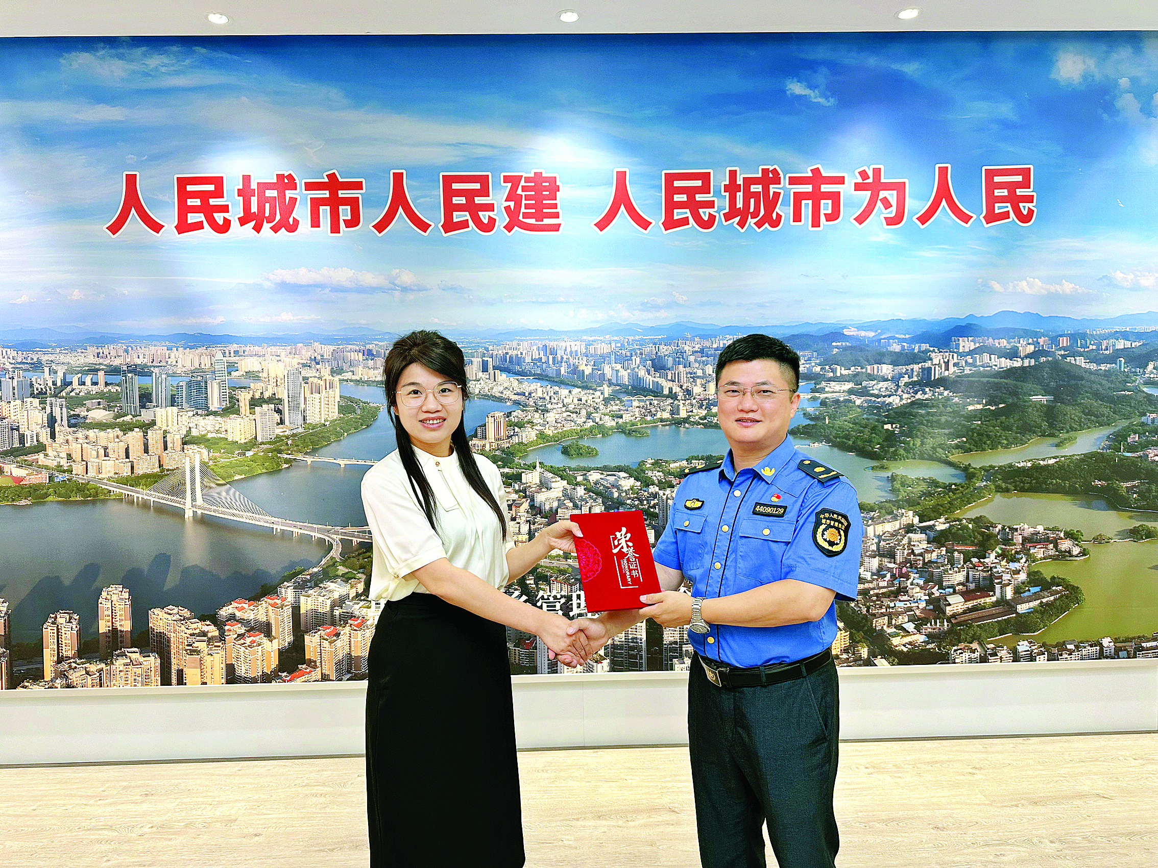     新联社区工作人员为黄伟斌（右）颁发荣誉证书。