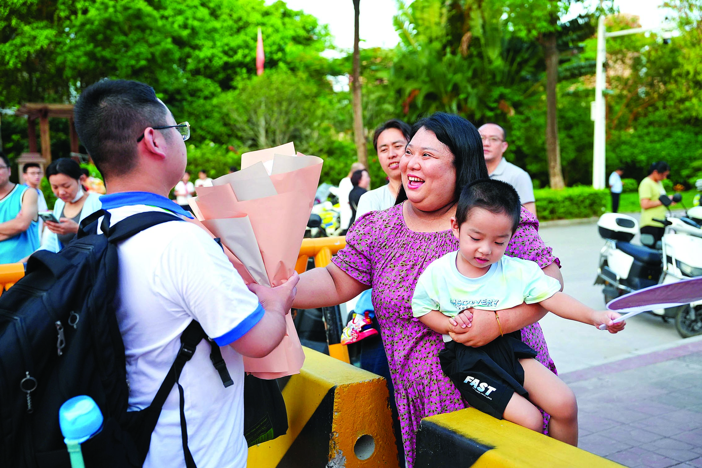     高考结束后，家长向考生递过鲜花。 惠州日报记者黄旭新 摄