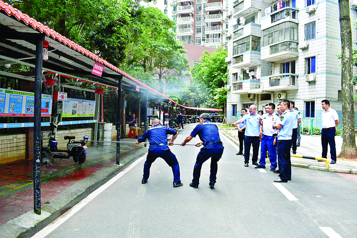     金沙俊园小区开展消防演习，设备喷淋灭火后，物业人员勾出起火车辆。