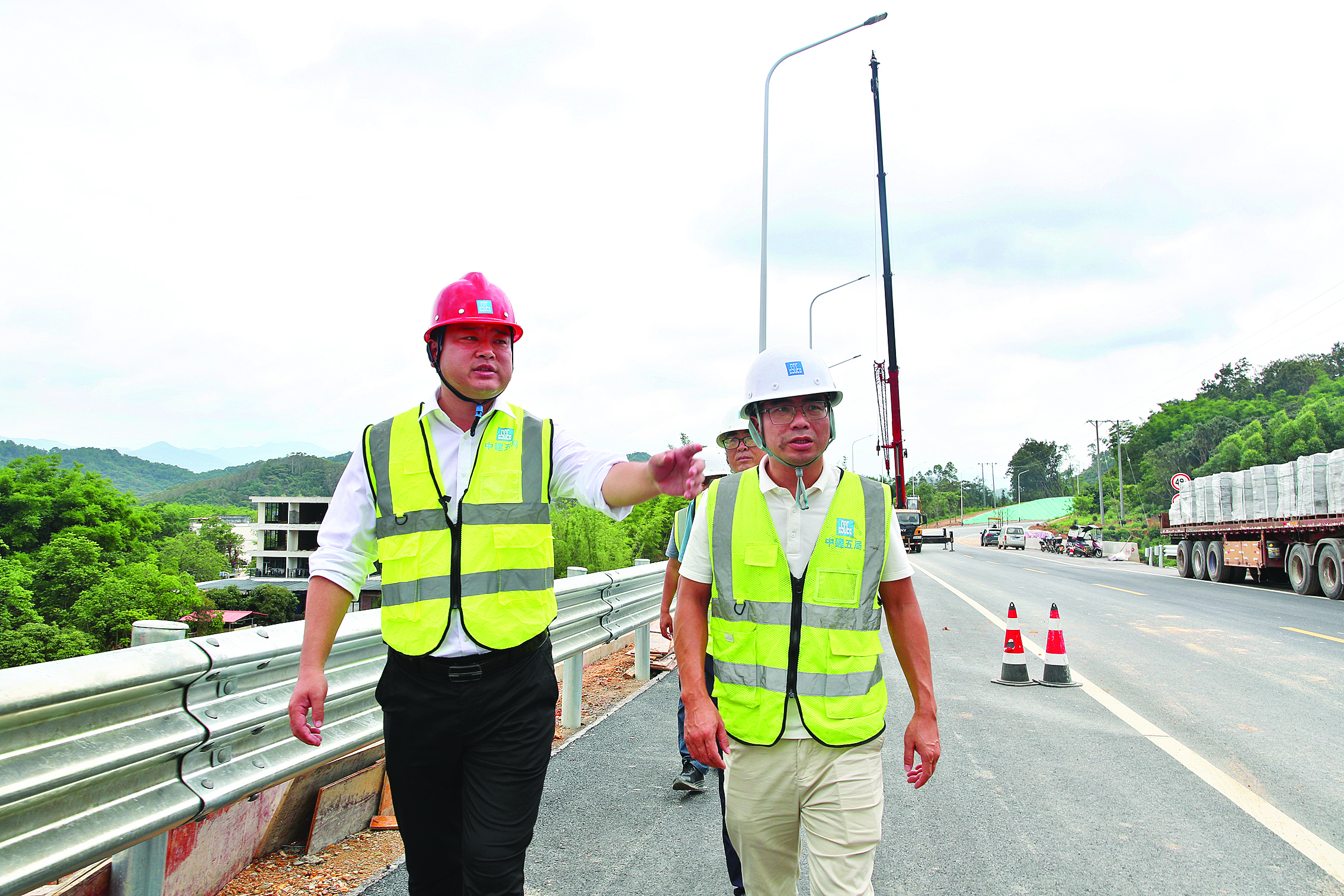     许松（左一）在公路施工现场督战。惠州日报记者钟畅新 摄