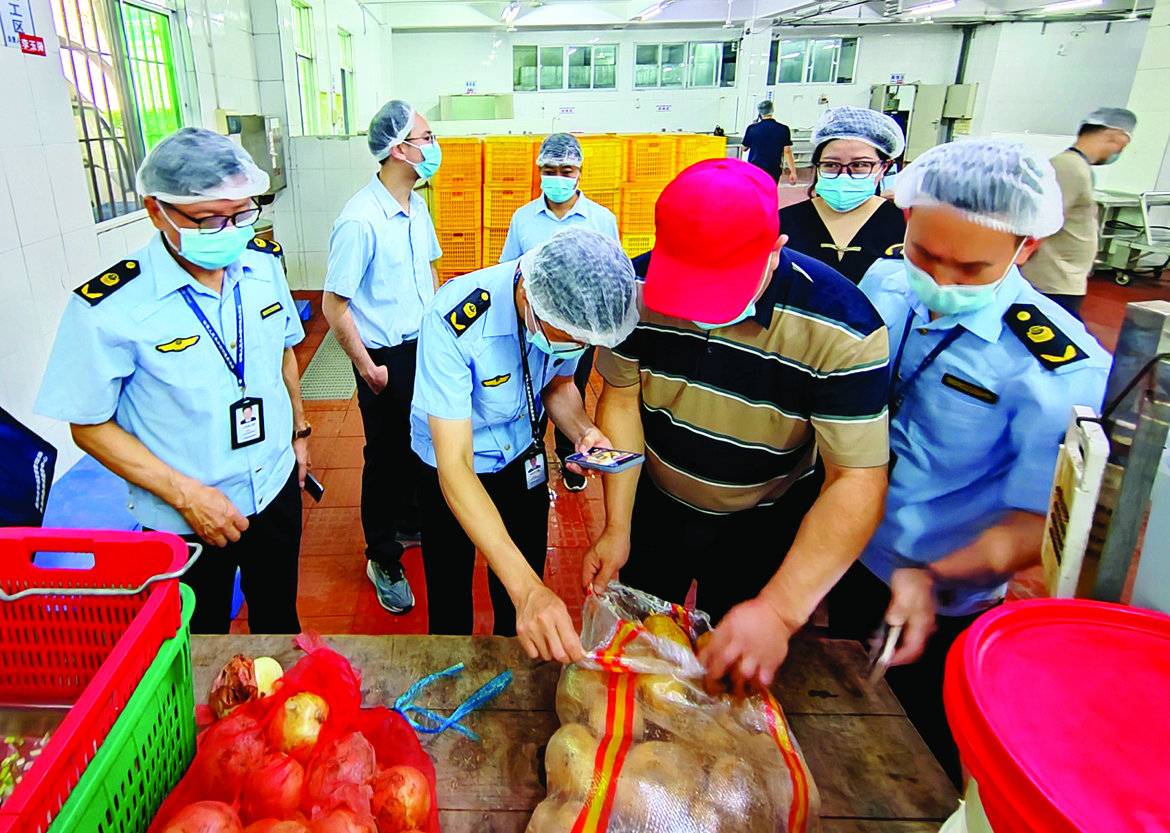     执法人员在检查学校食堂食材。惠州市市场监督管理局供图