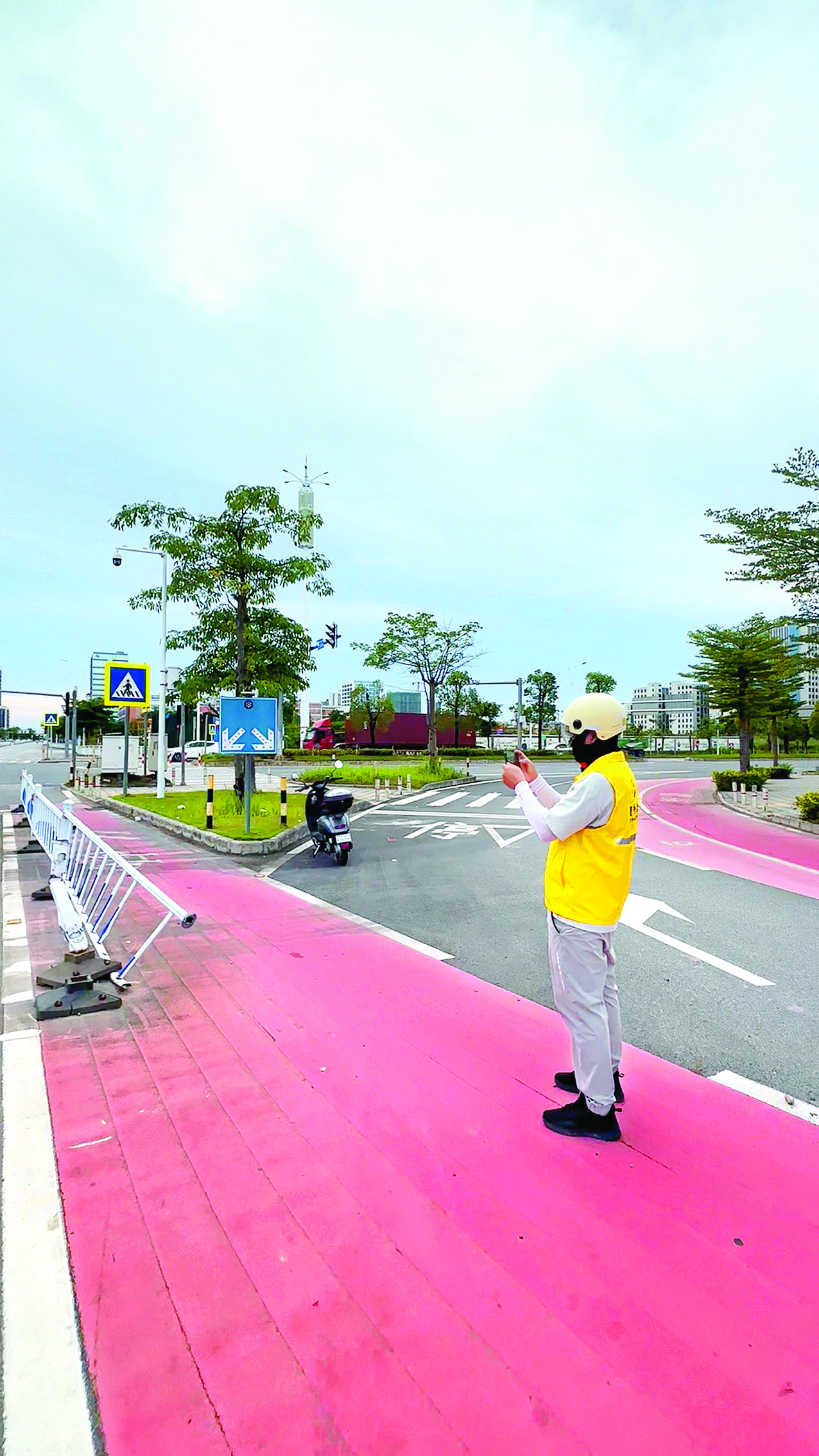     邱剑念在送外卖过程中，发现路上一处护栏坏了，停下来拍照记录。惠州日报记者汤渝杭 摄