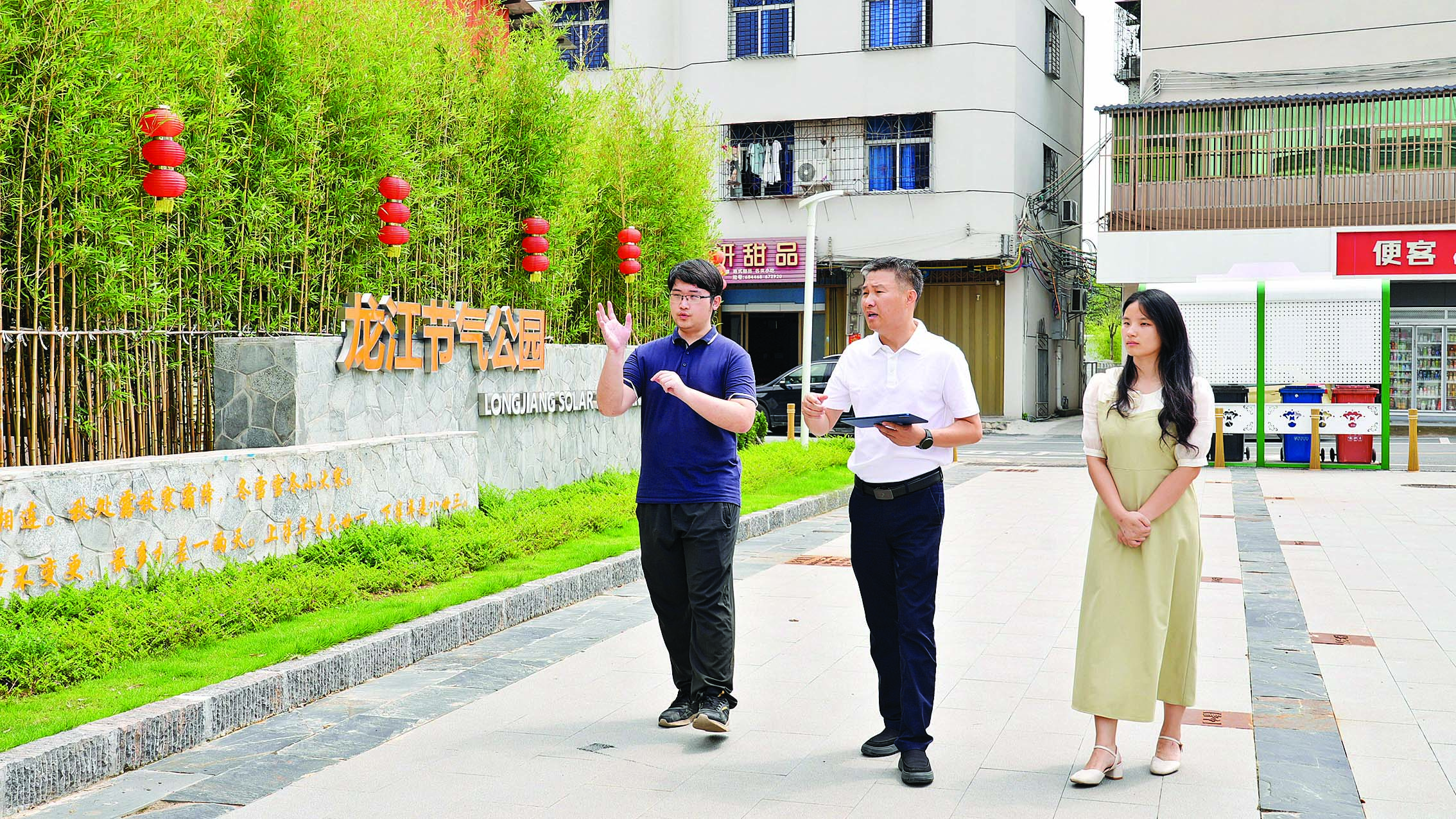     张锐源（中）与镇政府工作人员一同到龙江圩镇示范主街调研。    惠州日报记者汤渝杭 摄