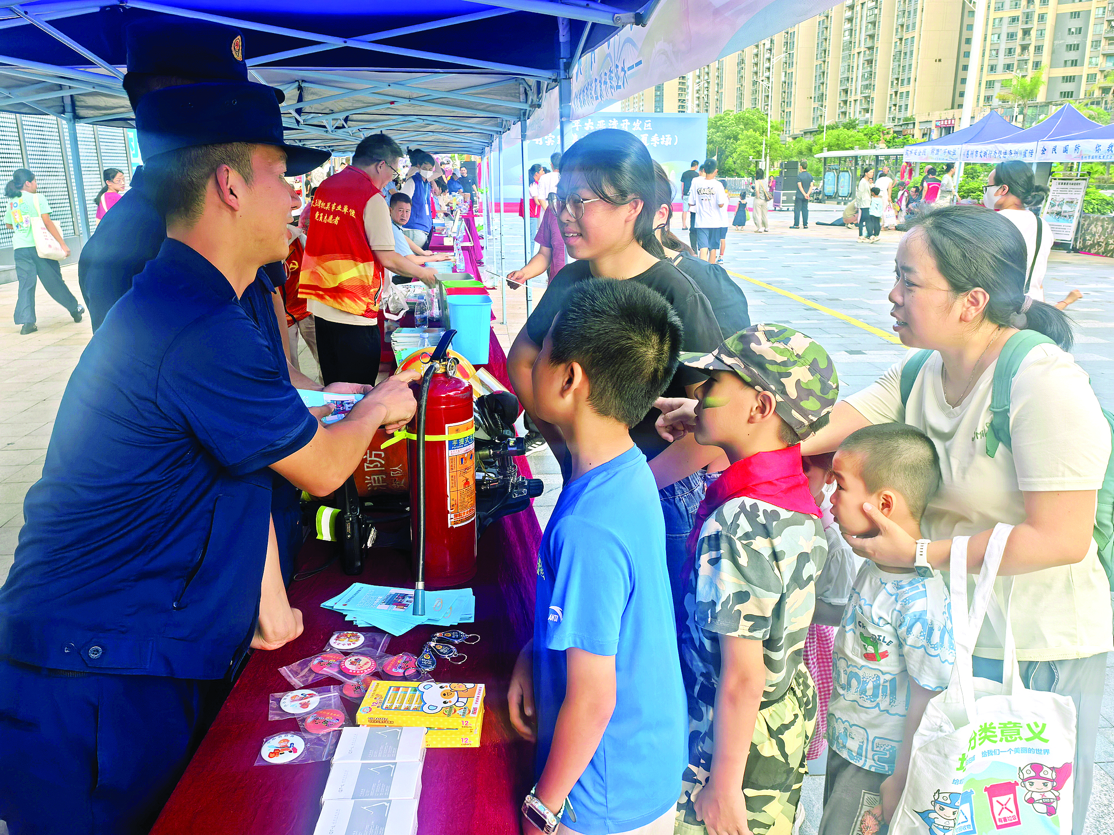     集市上消防员介绍灭火器使用技巧。    惠州日报记者张宇琪 通讯员邹弋 摄